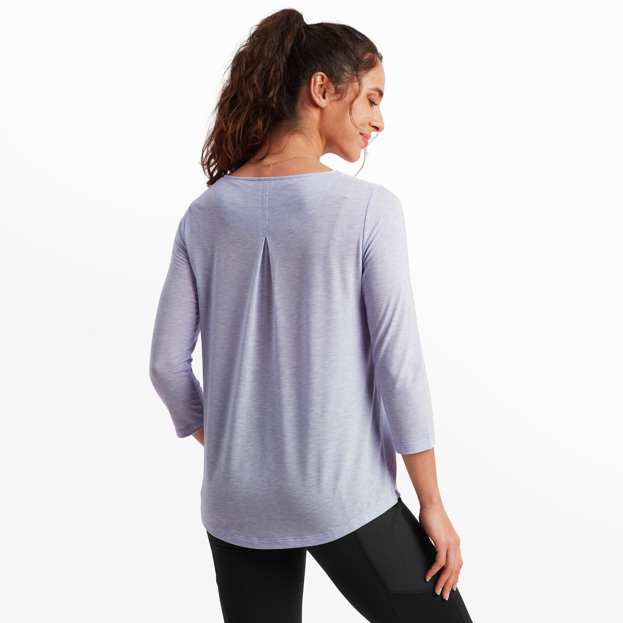 The back of the Sherpa Adventure Gear Asha 3/4 Sleeve Top in Purple reveals a slight pleat detail below the neckline, adding a touch of subtle design to the otherwise simple silhouette. The sleeves and hem maintain the same relaxed and comfortable style.