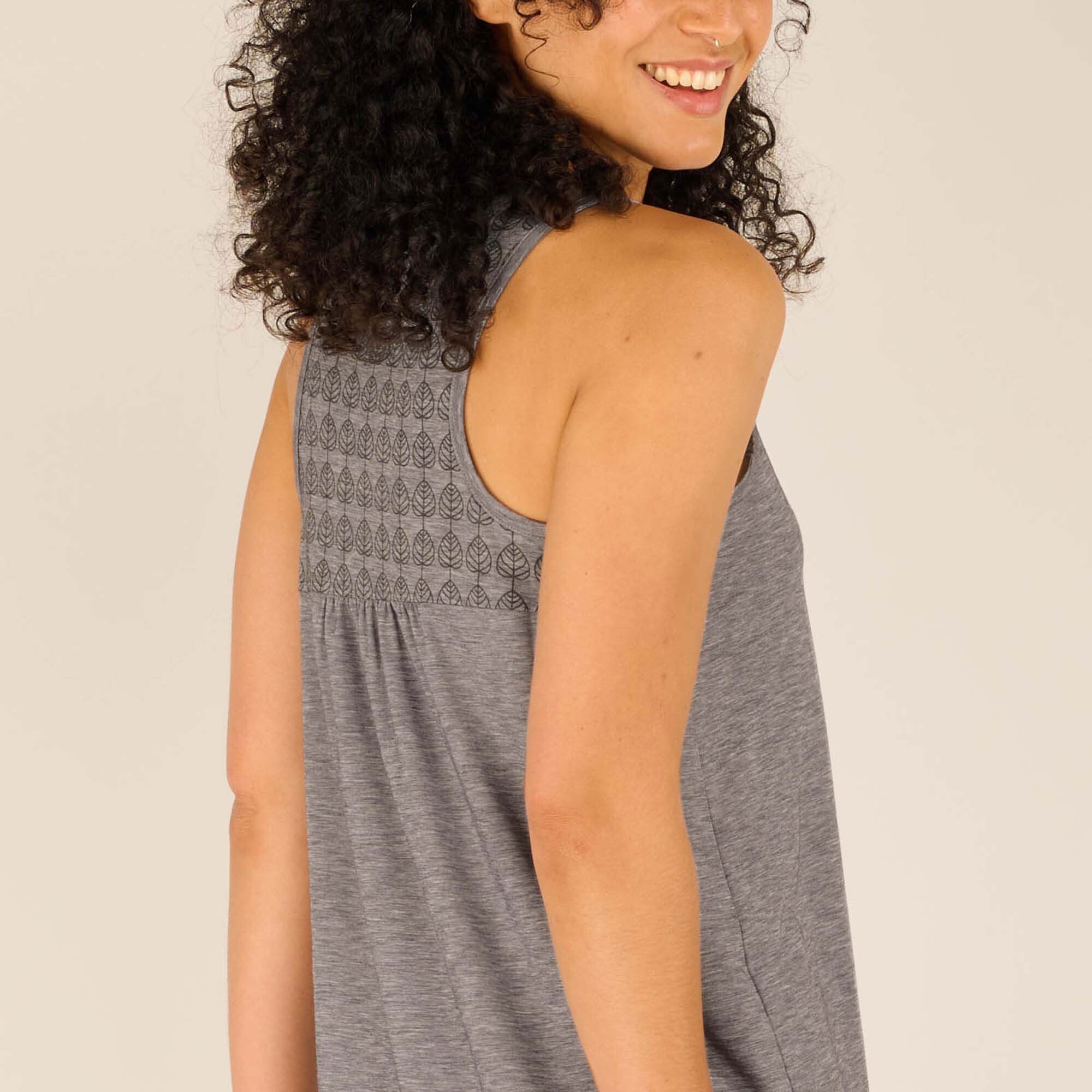 A detailed view of the upper back of the Sherpa Adventure Gear Asha Tank in Grey, showcasing the intricate leaf-patterned yoke design. The texture of the soft fabric is visible in the close-up.