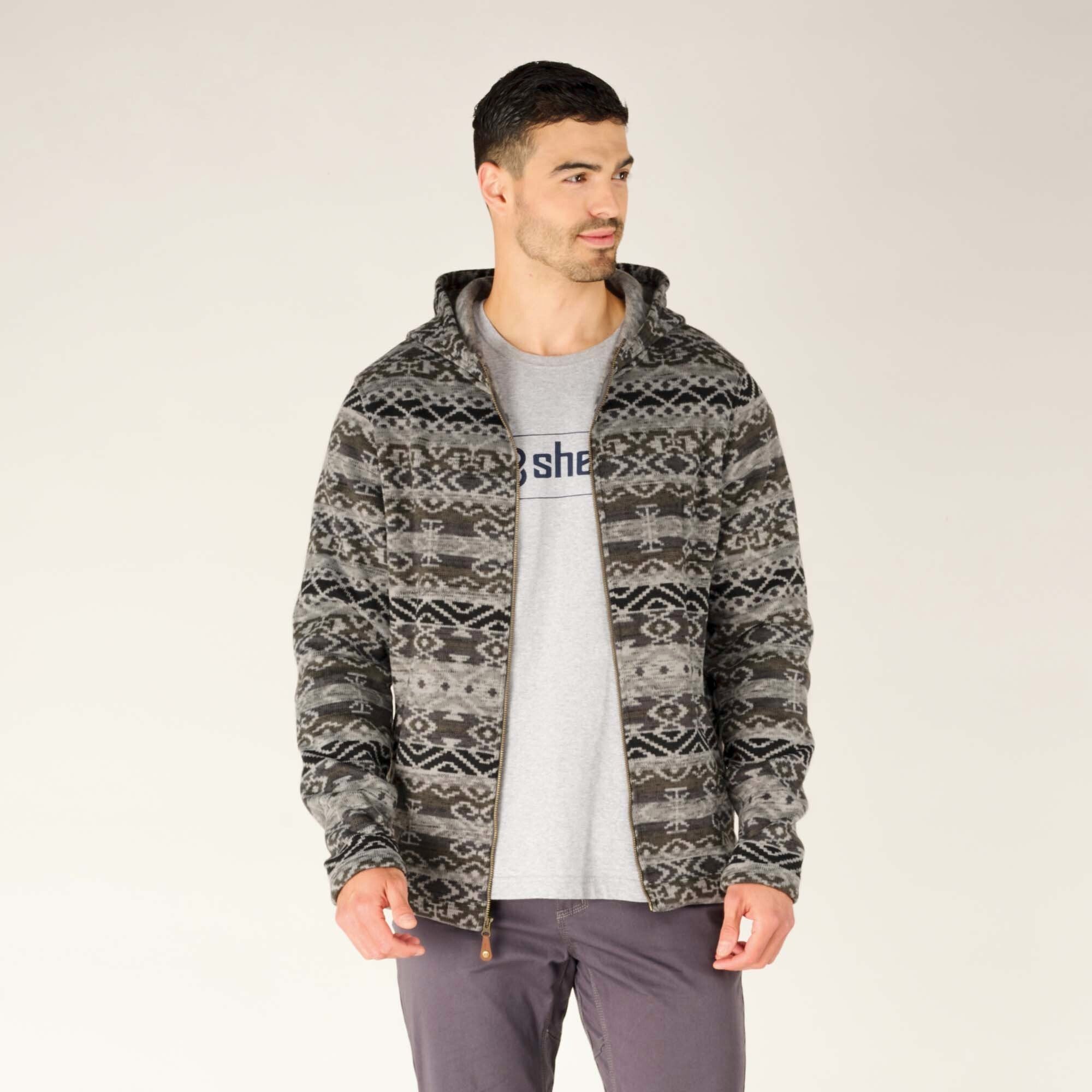 The model is wearing the Sherpa Adventure Gear Bhutan Full Zip Hoodie in Grey unzipped, revealing a grey graphic T-shirt underneath. The interior of the hoodie appears to have a soft fleece lining.