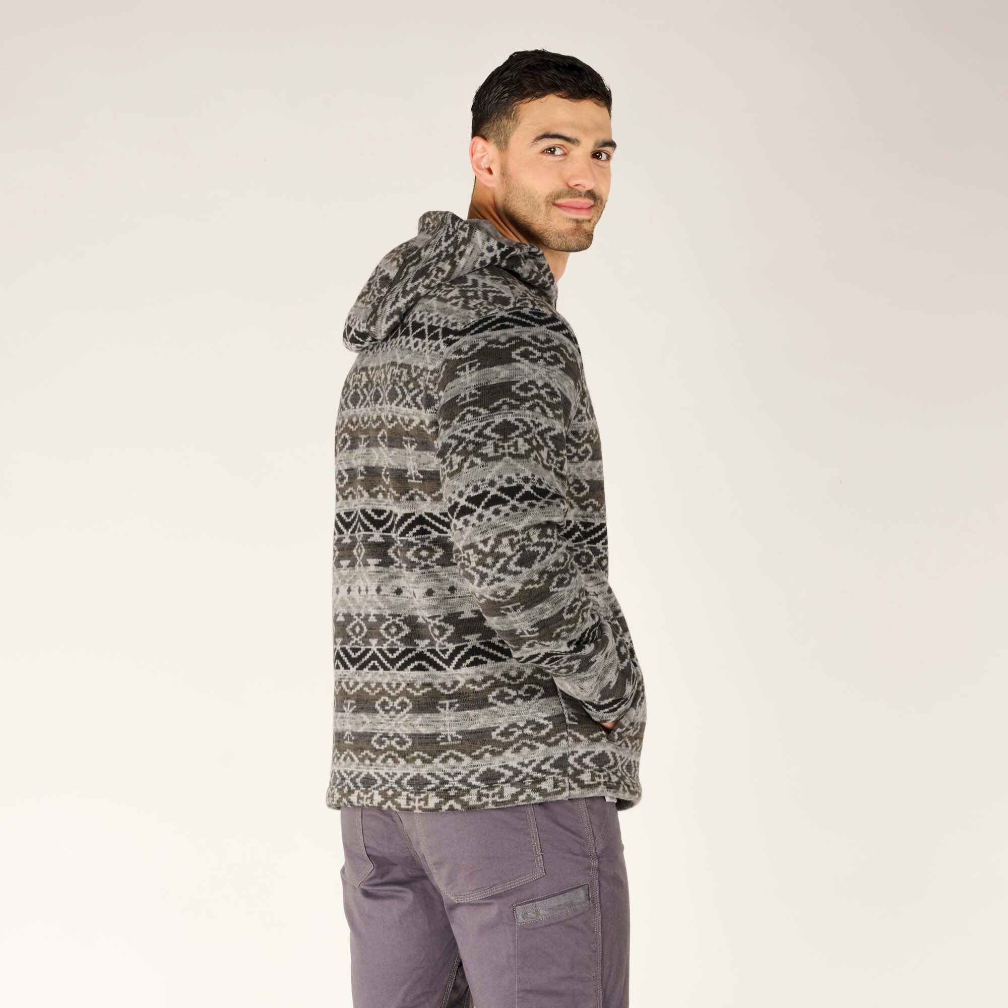 The model has his hands inside the Sherpa Adventure Gear Bhutan Full Zip Hoodie in Grey’s side pockets, highlighting their spacious and functional design. The relaxed fit of the hoodie is visible.