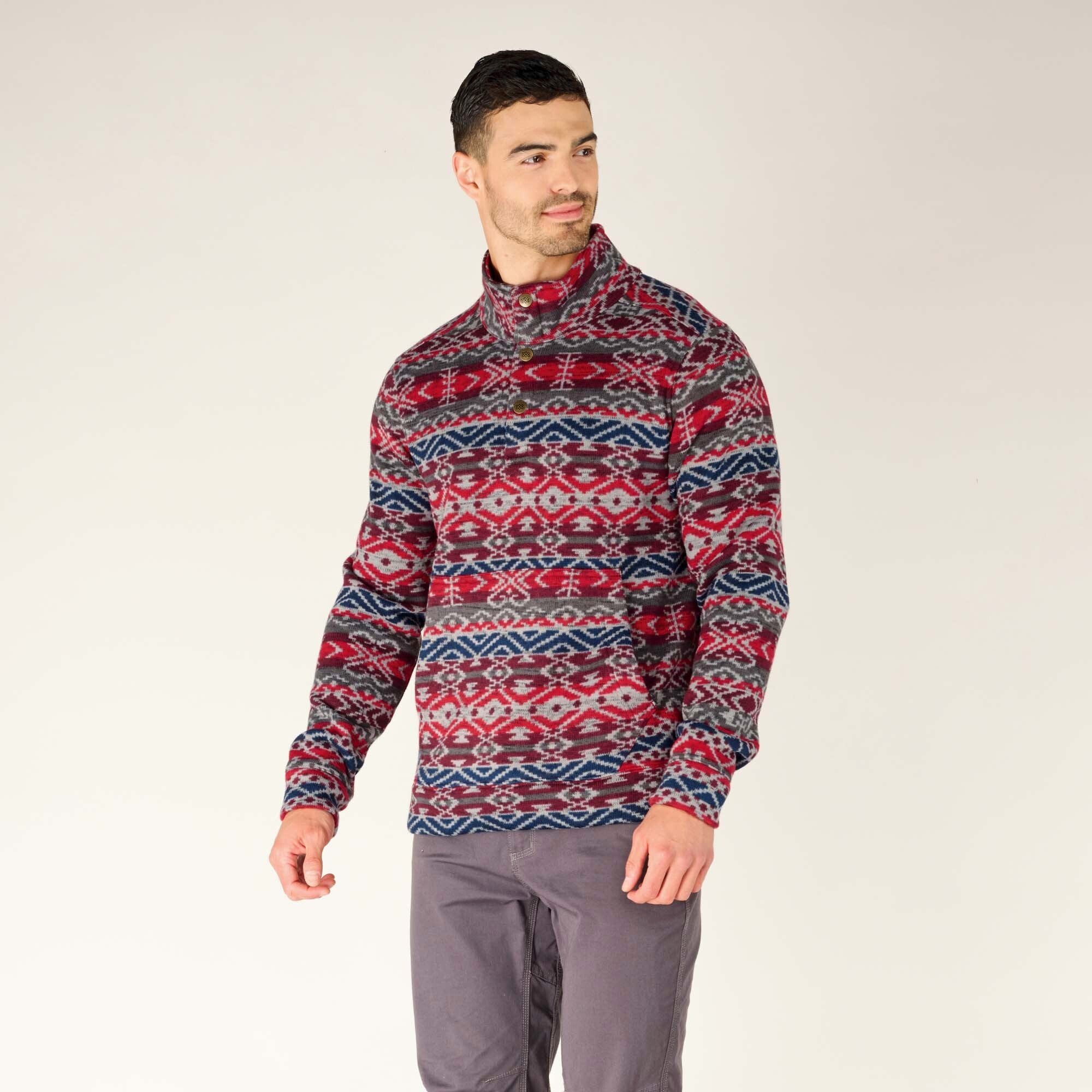 A side-facing view of the man wearing the Sherpa Adventure Gear Bhutan Pullover in Blue, turned slightly towards the camera. This angle highlights the fit of the pullover's sleeves and its seamless pattern that extends to the sides.