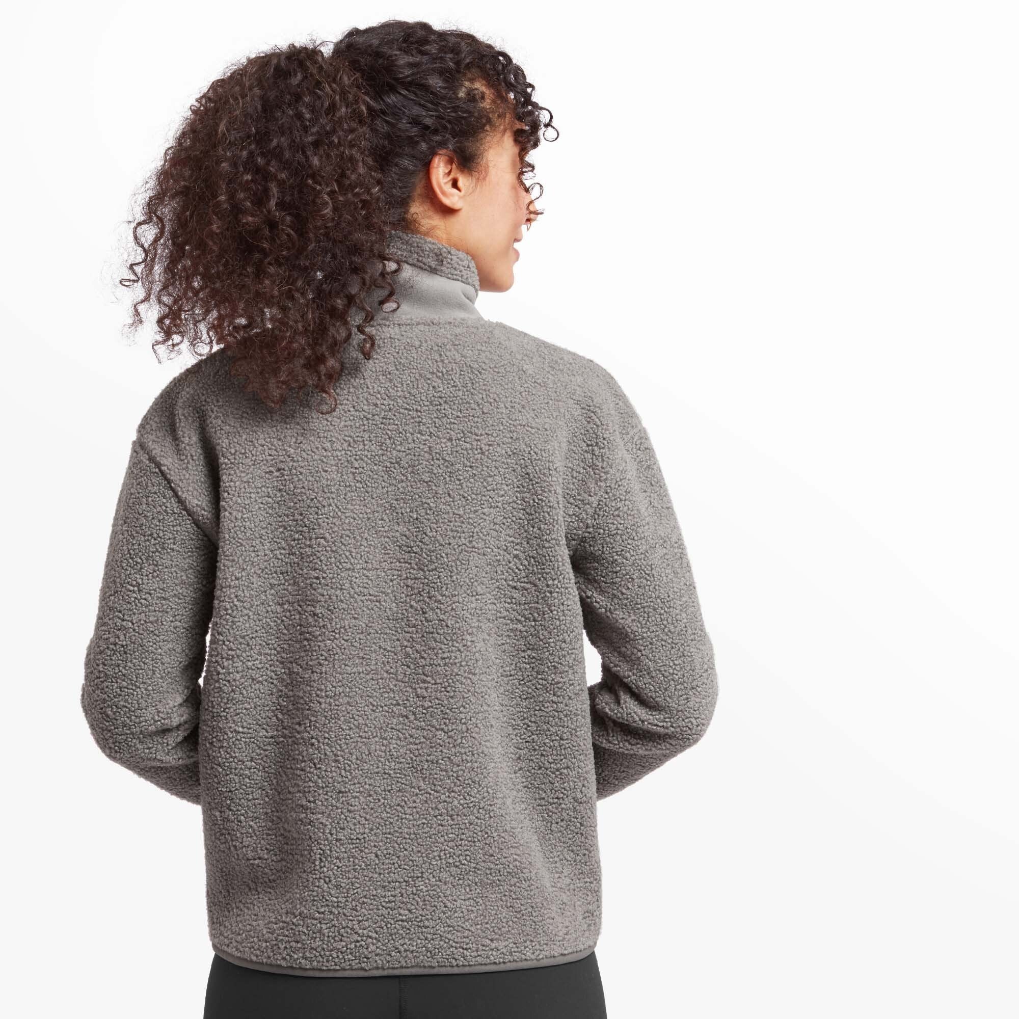 A back view of the Sherpa Adventure Gear Chamlang Half Zip Pullover in Grey, highlighting its simple and cozy design. The high collar and thick fleece texture are visible, emphasising warmth and comfort.