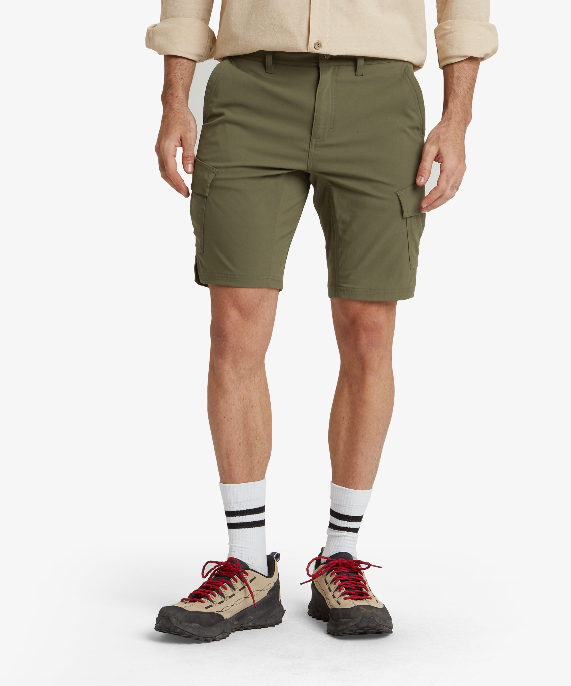 Close-up view of the front of Sherpa Adventure Gear Bara Cargo Shorts in Green, showcasing the clean and structured waistband with belt loops and a central button fastening. The image highlights the smooth fabric texture and the design of the side pockets, emphasising practicality.