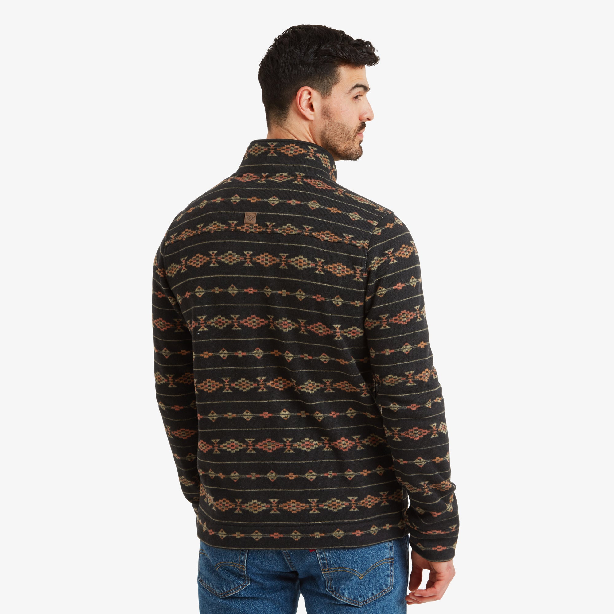 The rear view reveals the symmetrical patterning across the back of the jacket. The high collar provides additional coverage, and the small Sherpa logo is subtly placed below the collar, blending with the design.