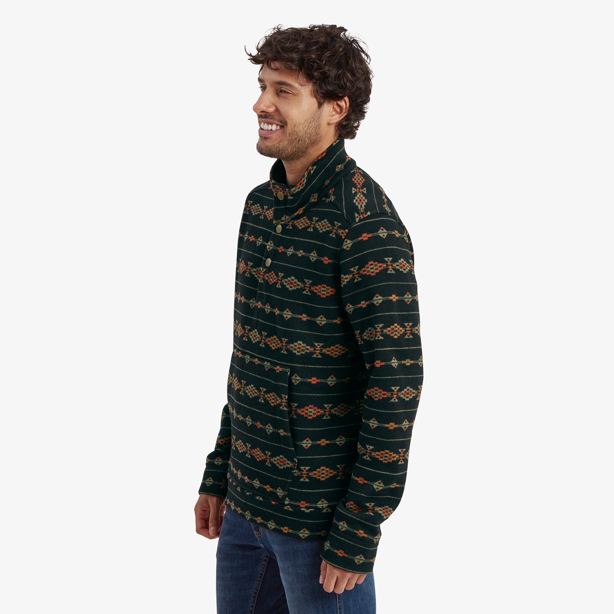 A side profile of the man wearing the same Sherpa Adventure Gear Bhutan Pullover in Black. He is smiling, showcasing the pullover's clean side seam and the continuation of the geometric design.