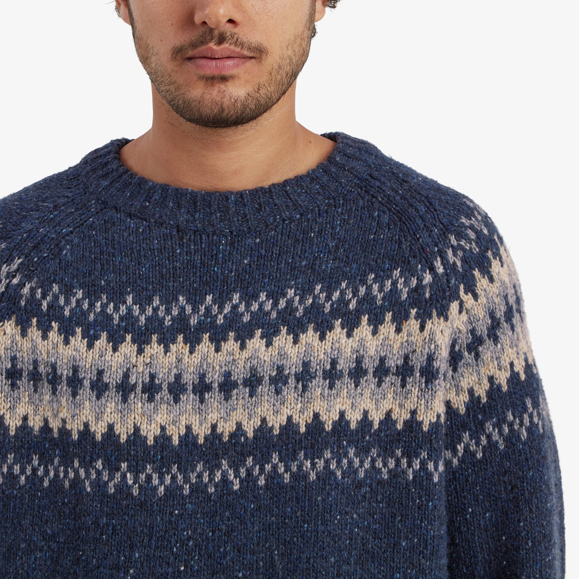 A detailed close-up of the geometric pattern, highlighting the intricacies of the knit and the blend of blue, cream, and gray colors. The craftsmanship of the Sherpa Adventure Gear Dumji Sweater in Blue is evident in the stitching.