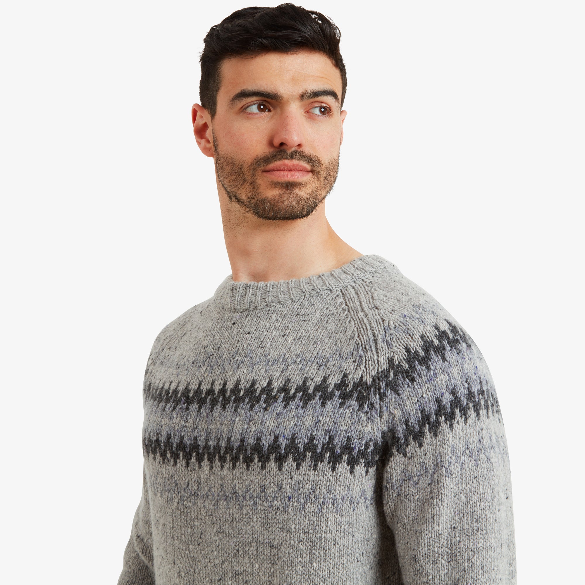 A close-up of the Sherpa Adventure Gear Dumji Sweater in Brown’s neckline and shoulder area, emphasising the neat stitching and detailing in the ribbed neck. The traditional geometric pattern is highlighted against the textured knit.