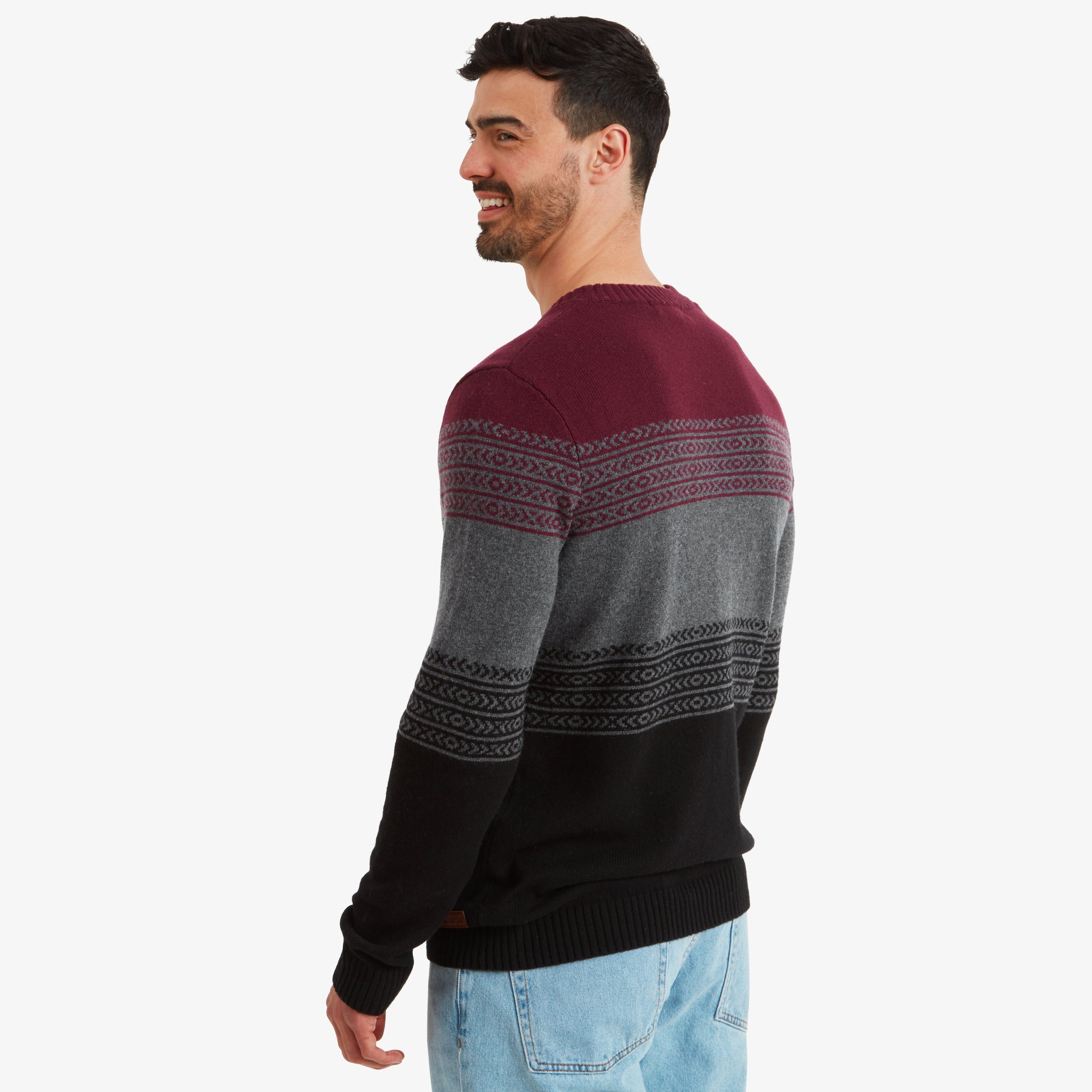 The back of the Sherpa Adventure Gear Hatauda Crew in Grey is shown as the model turns slightly, revealing the seamless continuation of the striped pattern on the back.