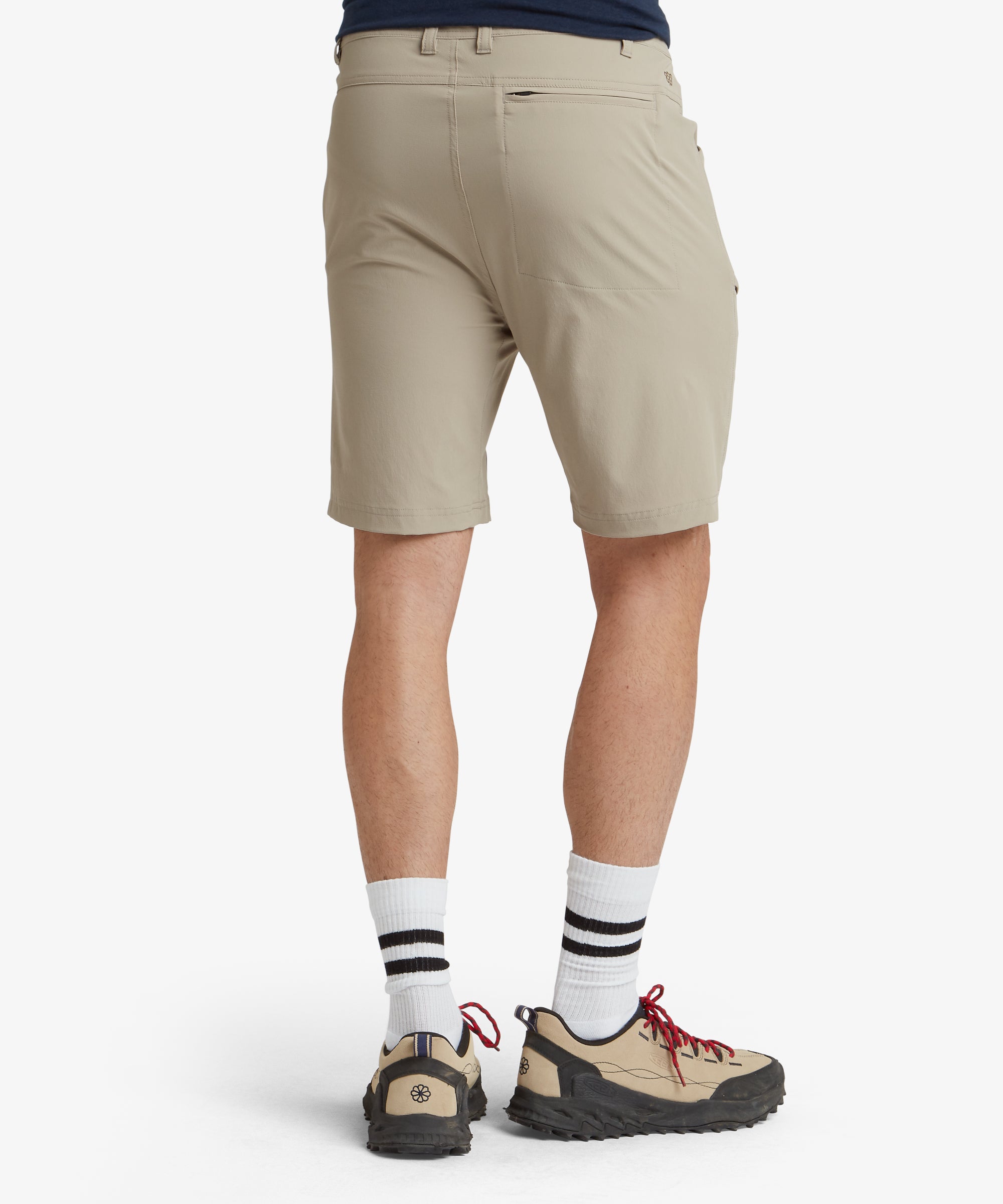 An angled view of the Sherpa Adventure Gear Jamyang Shorts in Beige combines elements of the front and side, focusing on the contours and functional pockets. The clean stitching and neutral beige color are highlighted in this shot, perfect for showcasing the shorts' versatile style.