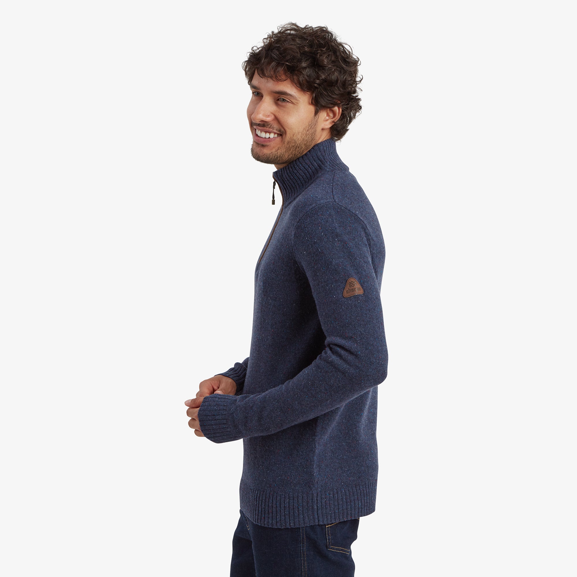 A side view highlights the Sherpa Adventure Gear Kangtega Quarter Zip Sweater in Blue's fit, with ribbed cuffs and a hem that maintains a neat silhouette. A brown Sherpa logo patch is visible on the sleeve, adding a unique brand detail.