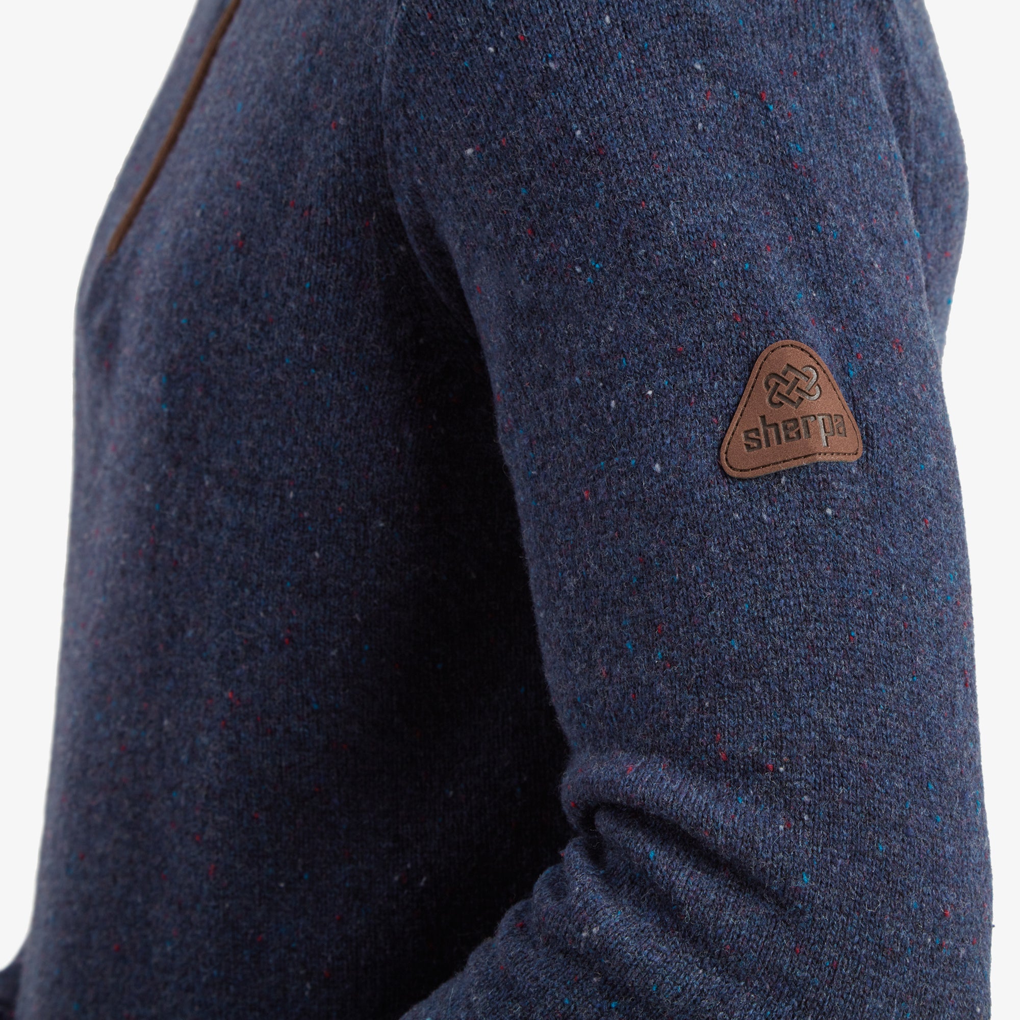 A zoomed-in view of the front zipper illustrates the high-quality metal zip with a suede pull tab, complementing the Sherpa Adventure Gear Kangtega Quarter Zip Sweater in Blue’s elegant and functional design.