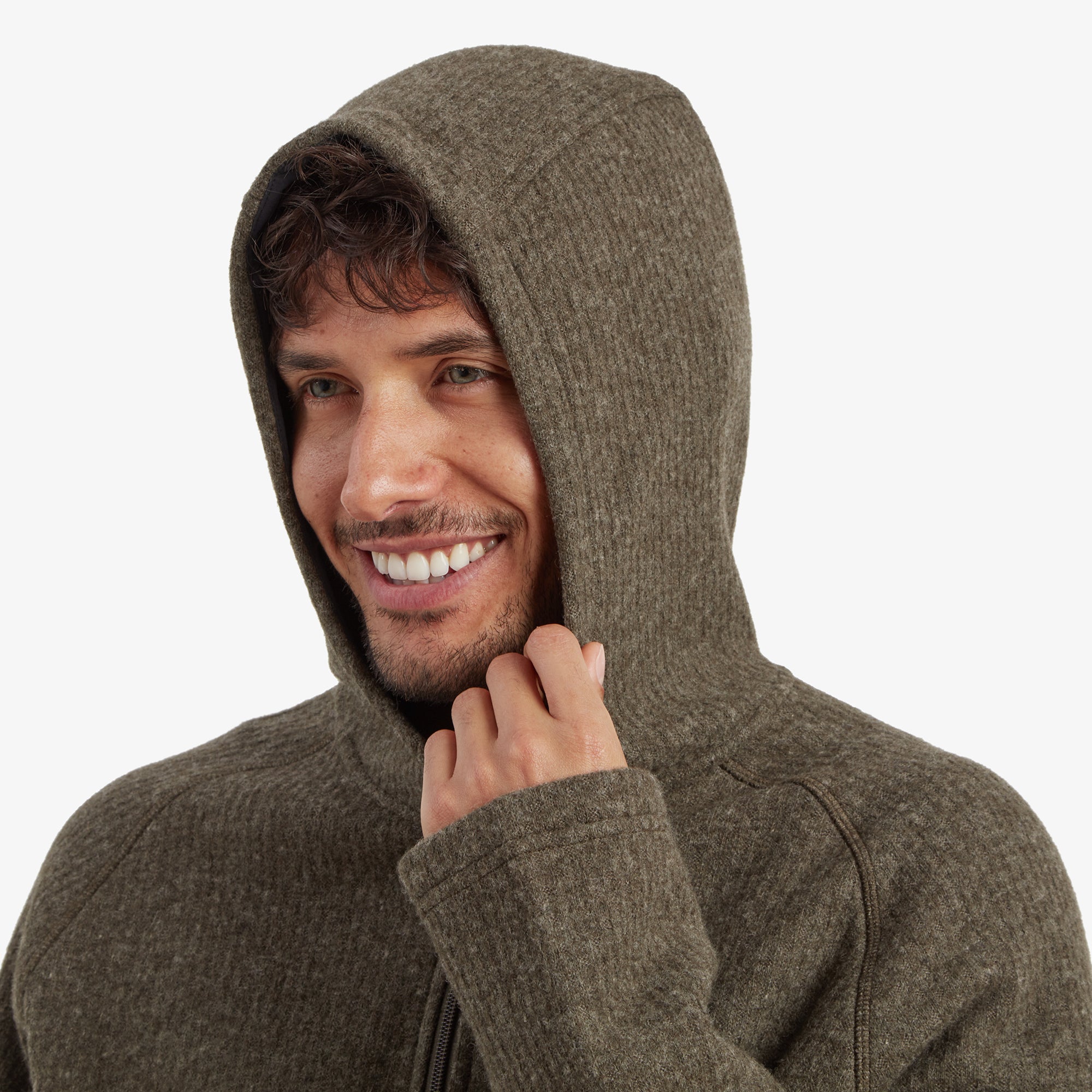 The model wearing the Sherpa Adventure Gear Namgyal Hoodie in Green with the hood up, smiling warmly. This image showcases the cozy design of the hood and how it fits snugly around the head for warmth.