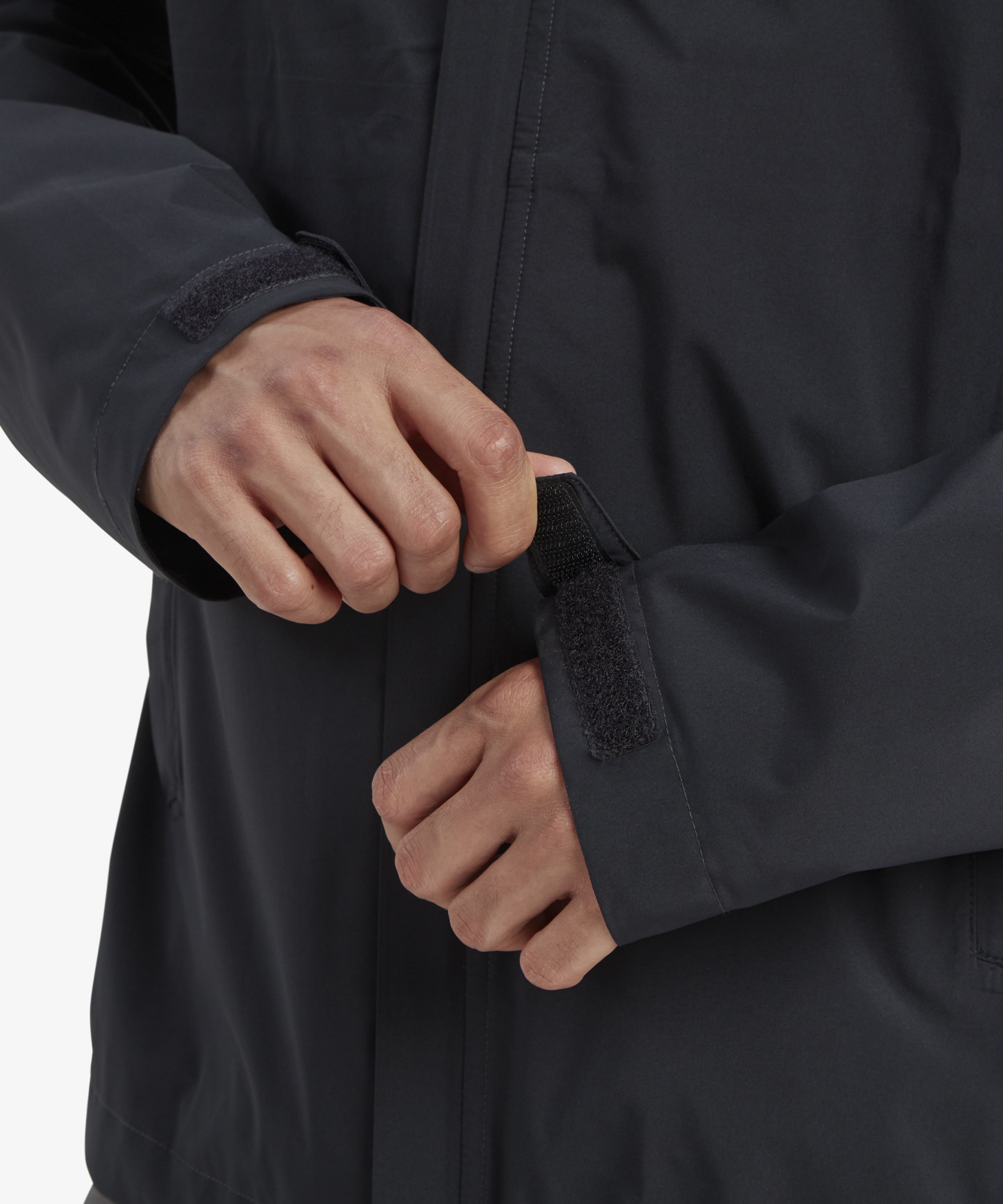 A close-up of the Sherpa Adventure Gear Nima 2.5-Layer Jacket in Black’s underarm zippered vent, partially opened to reveal a breathable mesh lining underneath, designed for temperature regulation.