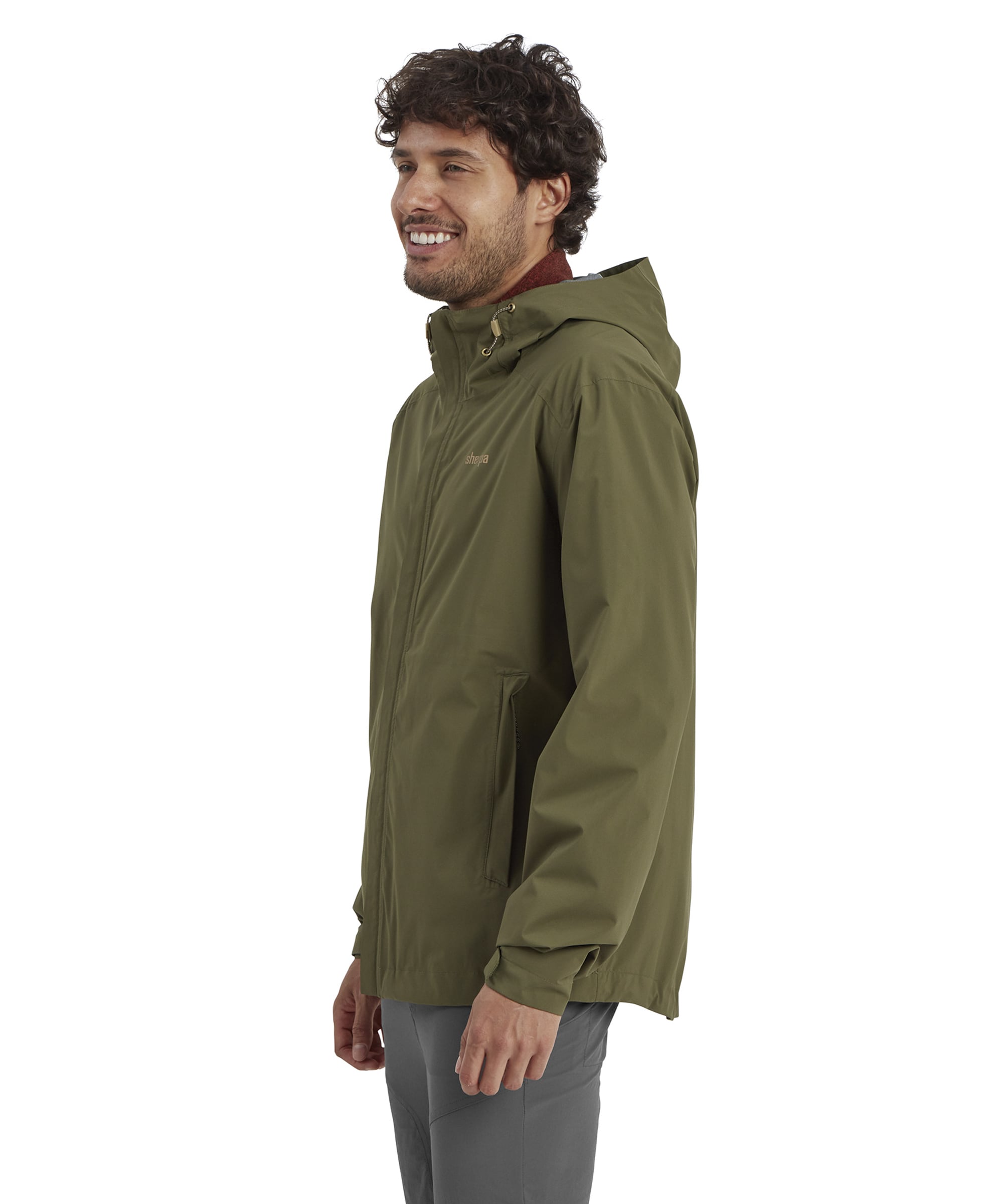 A side profile of the Sherpa Adventure Gear Nima 2.5-Layer Jacket in Green, emphasising its structured hood and the smooth, weather-resistant fabric. The man’s relaxed pose highlights the jacket’s ergonomic design for outdoor movement.