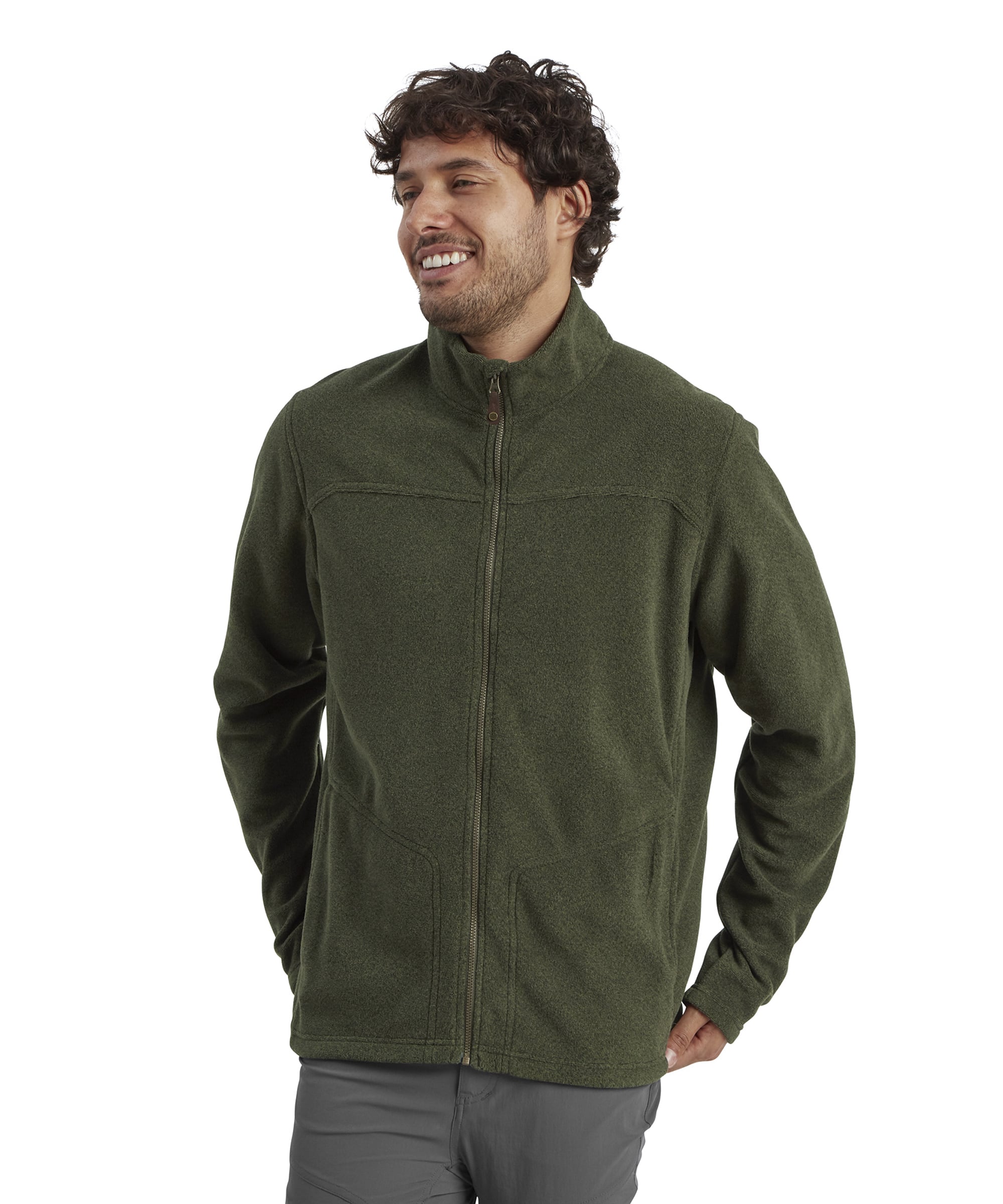 A man wearing a Sherpa Adventure Gear Rolpa Eco Jacket in Green with a full zipper. He is standing in a casual pose, smiling, with his right hand in his pocket. The jacket has a high collar and visible stitching around the chest area.