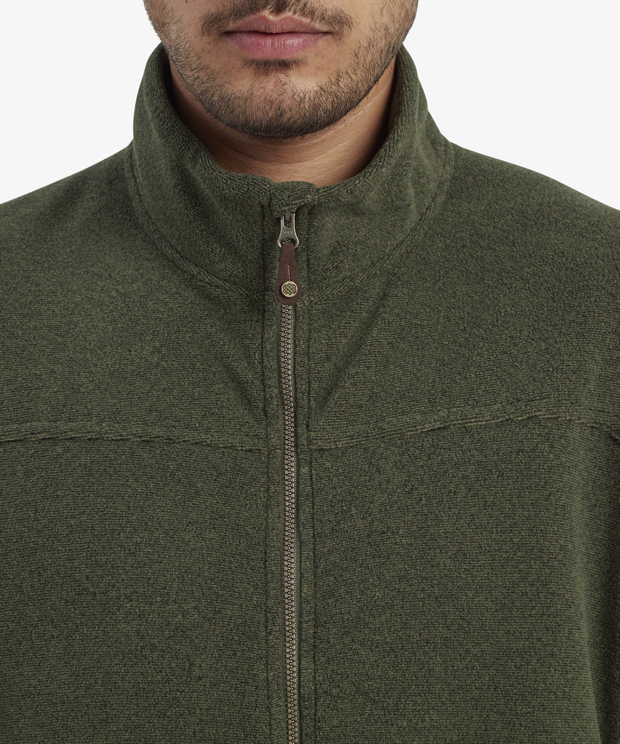 A close-up of the high collar and zipper details on the Sherpa Adventure Gear Rolpa Eco Jacket in Green. The collar is up, showcasing the fabric texture, leather pull tab on the zipper, and a secure fit around the neck.