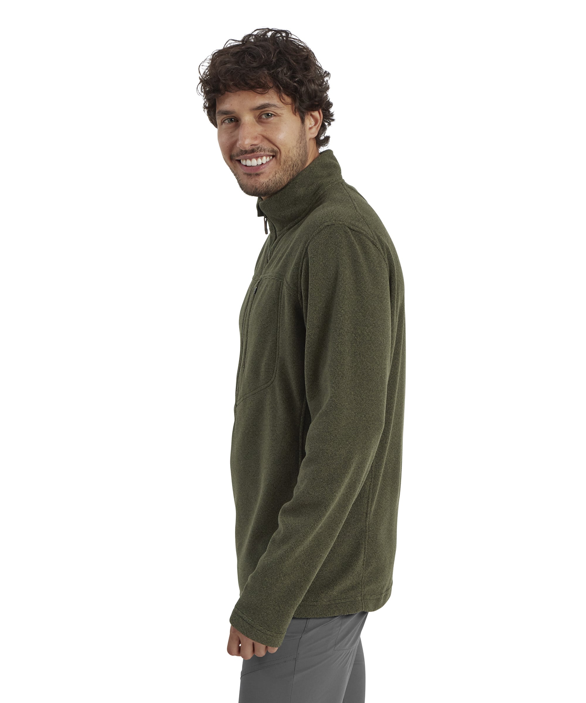 A side profile of the man wearing the olive green quarter zip. The image highlights the fit and structure of the garment's high collar and long sleeves, showcasing the relaxed yet slightly tailored silhouette. The man smiles naturally, demonstrating comfort in the outfit.