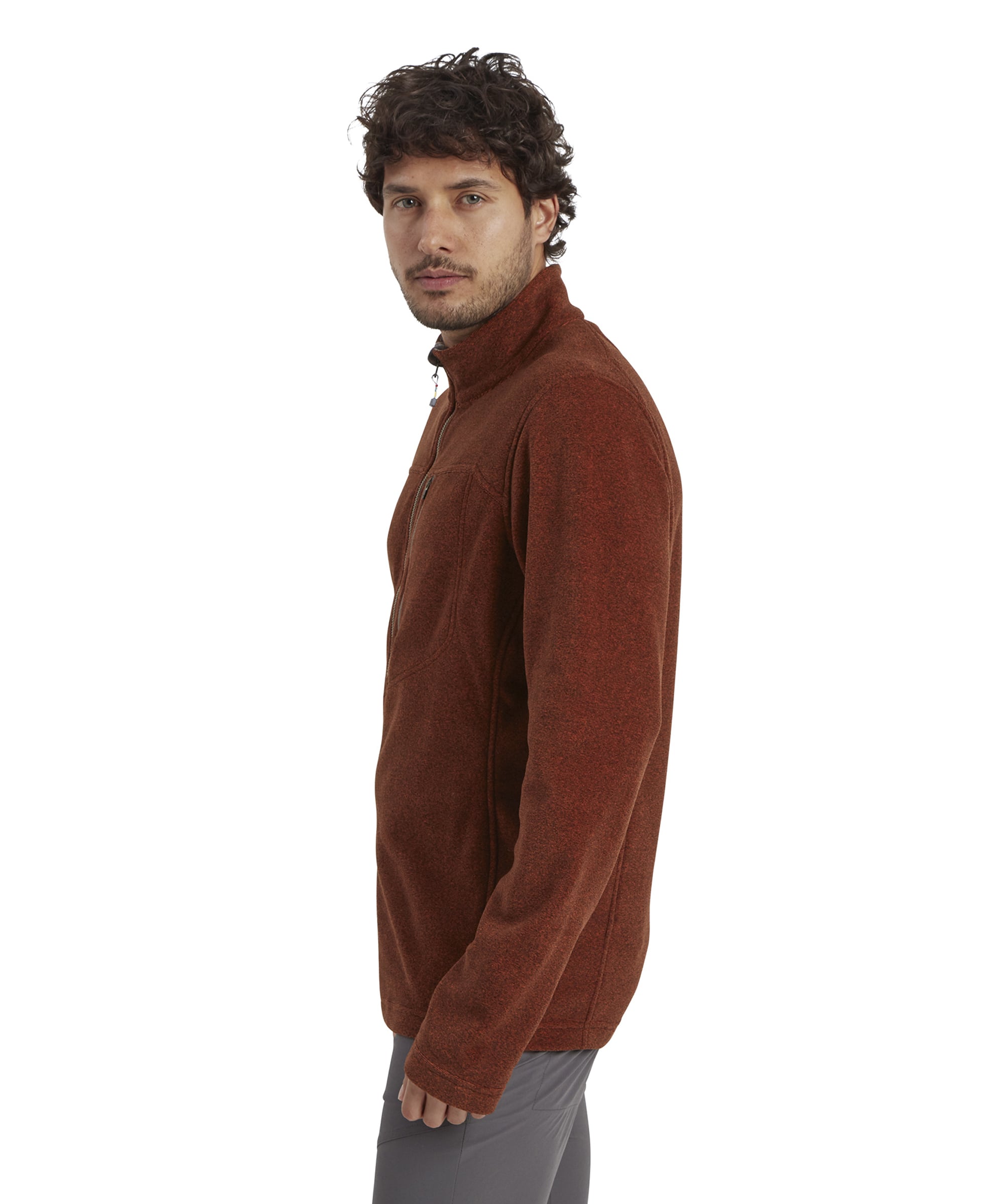 A side profile of the man wearing the Sherpa Adventure Gear Rolpa Eco Quarter Zip in Red, turned slightly to his right. The high collar and smooth silhouette of the pullover are emphasised, with the slim fit and textured material highlighted from this angle.