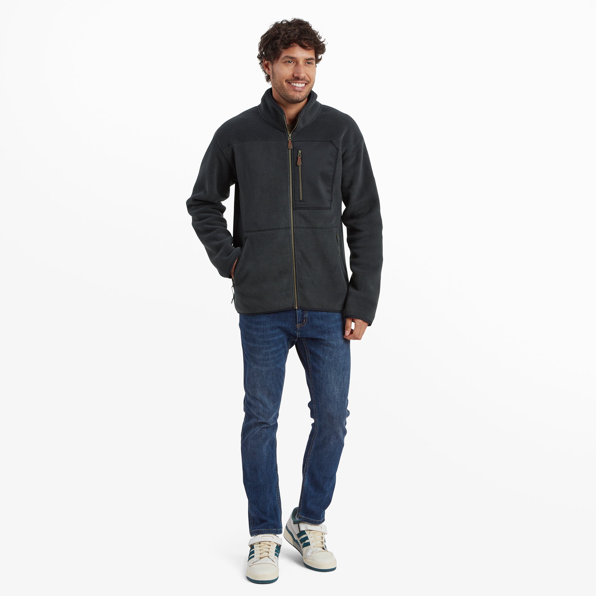 The model in a casual stance, emphasising the overall fit of the Sherpa Adventure Gear Sanani Eco Fleece Jacket in Black paired with jeans. The photo highlights the comfortable and versatile design of the jacket suitable for everyday wear.