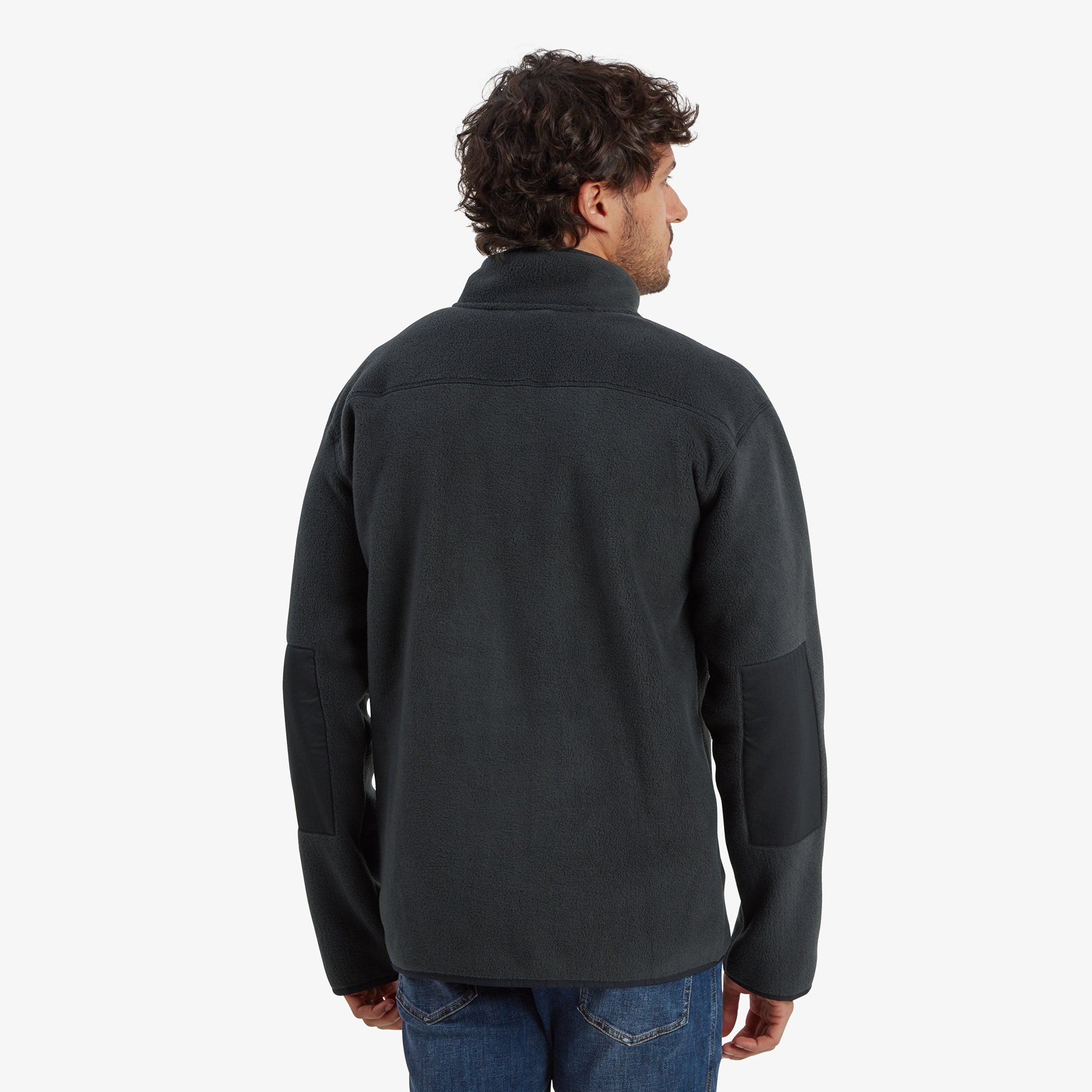 A back view of the Sherpa Adventure Gear Sanani Eco Fleece Jacket in Black, showing the clean and seamless design on the rear. The focus is on the jacket's length and how it sits naturally at the waistline.