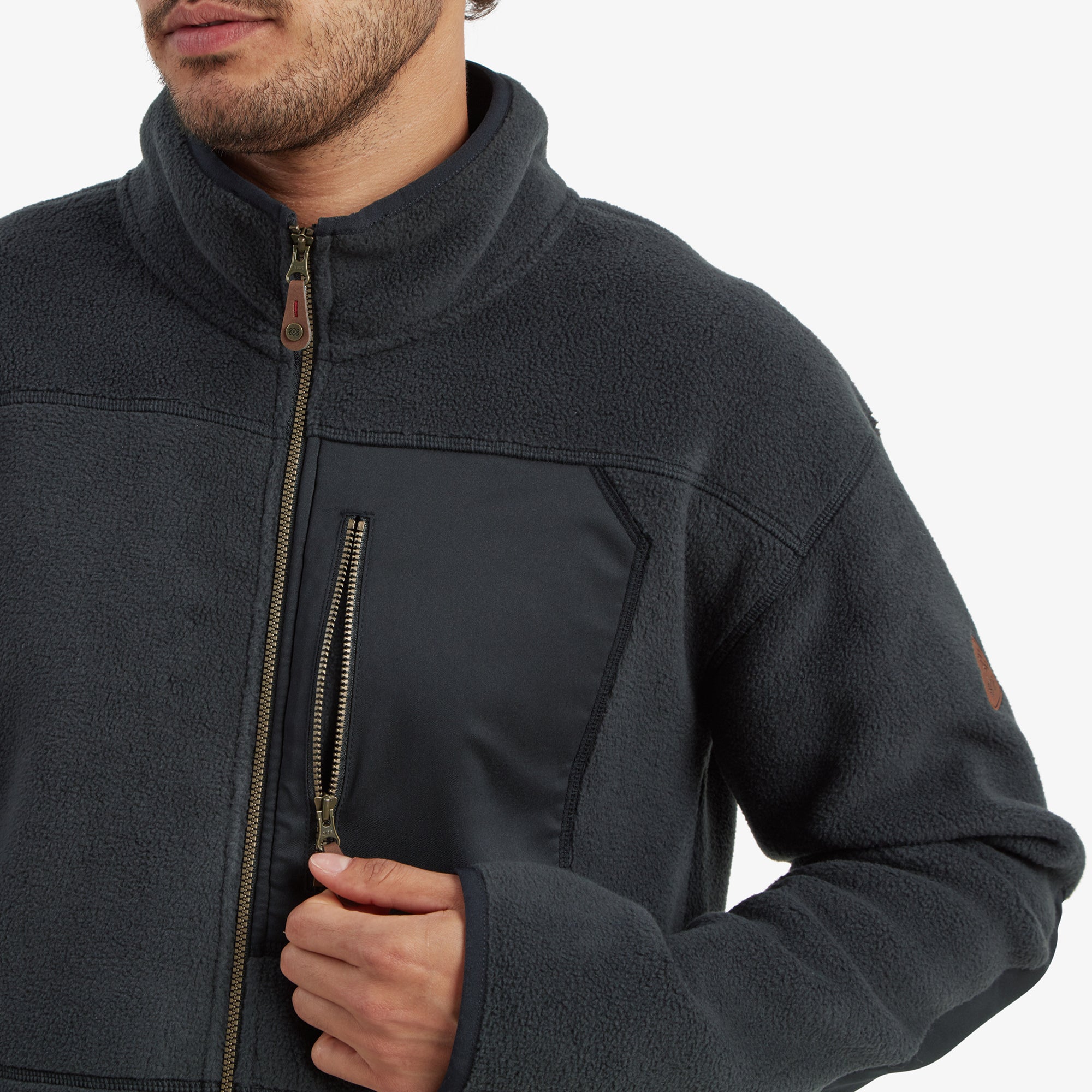 A close-up view of the Sherpa Adventure Gear Sanani Eco Fleece Jacket in Black's high collar and zipper, showcasing the high-quality material and detailing around the neckline, providing both style and warmth.