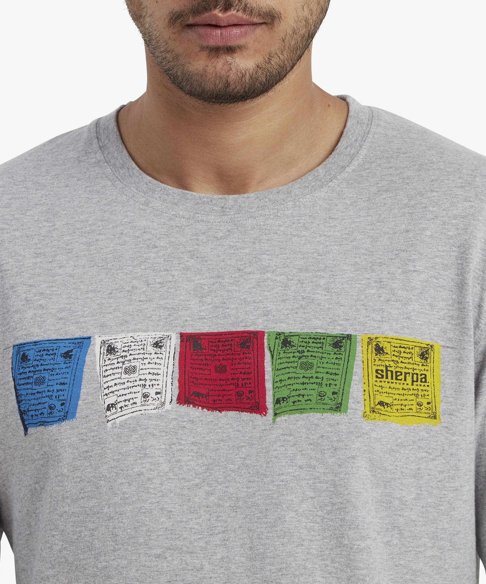 A zoomed-in detail of the prayer flag graphic on the chest. Each flag displays intricate patterns and texts that enhance the cultural and artistic appeal of the Sherpa Adventure Gear Tarcho Long Sleeve T-Shirt in Grey. The texture of the fabric is evident, highlighting the quality craftsmanship.