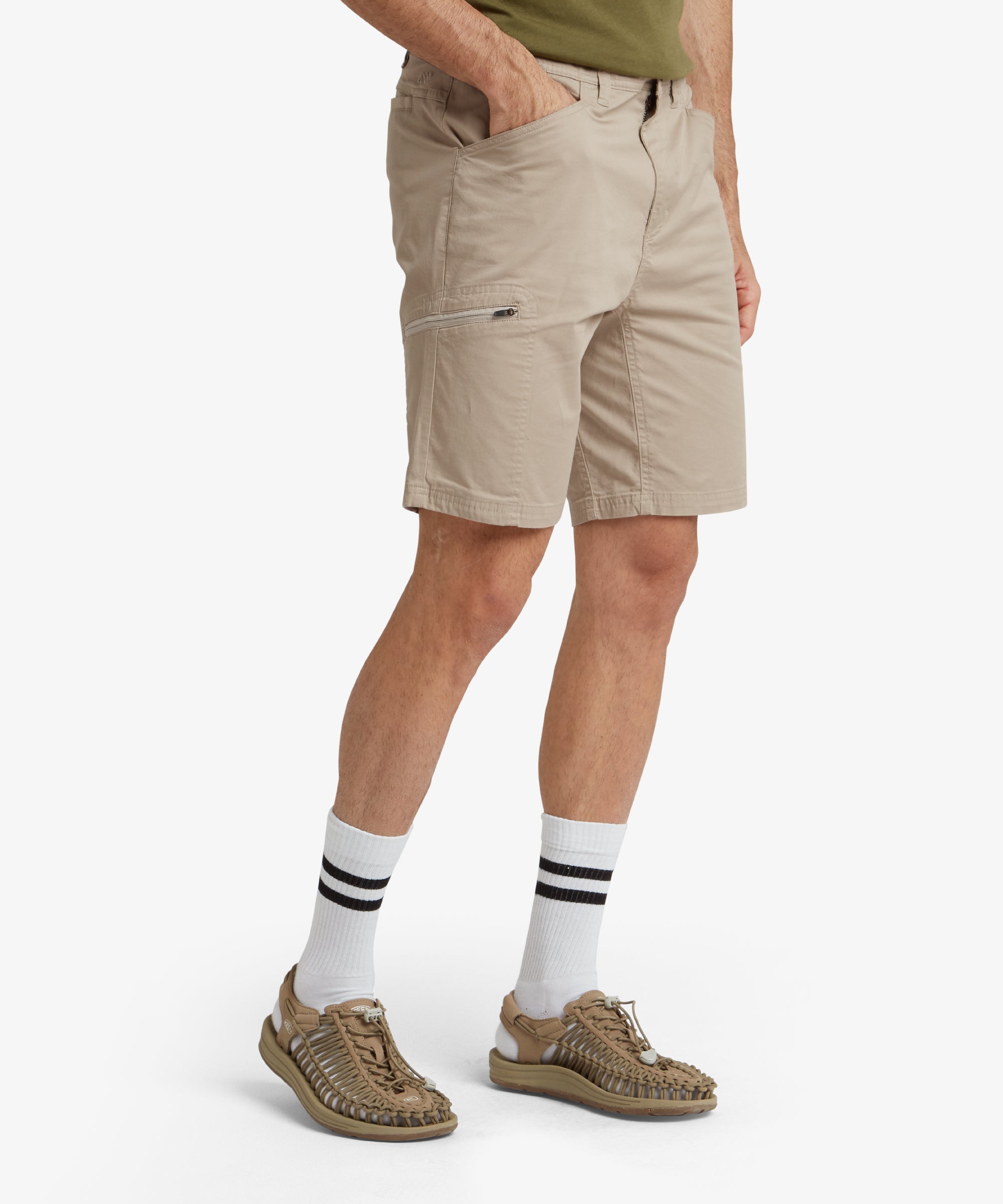 The back of the Sherpa Adventure Gear Tenjing Shorts in Beige is displayed, showing two streamlined back pockets with a clean and structured appearance. The model’s stance highlights the comfortable fit and length of the shorts.