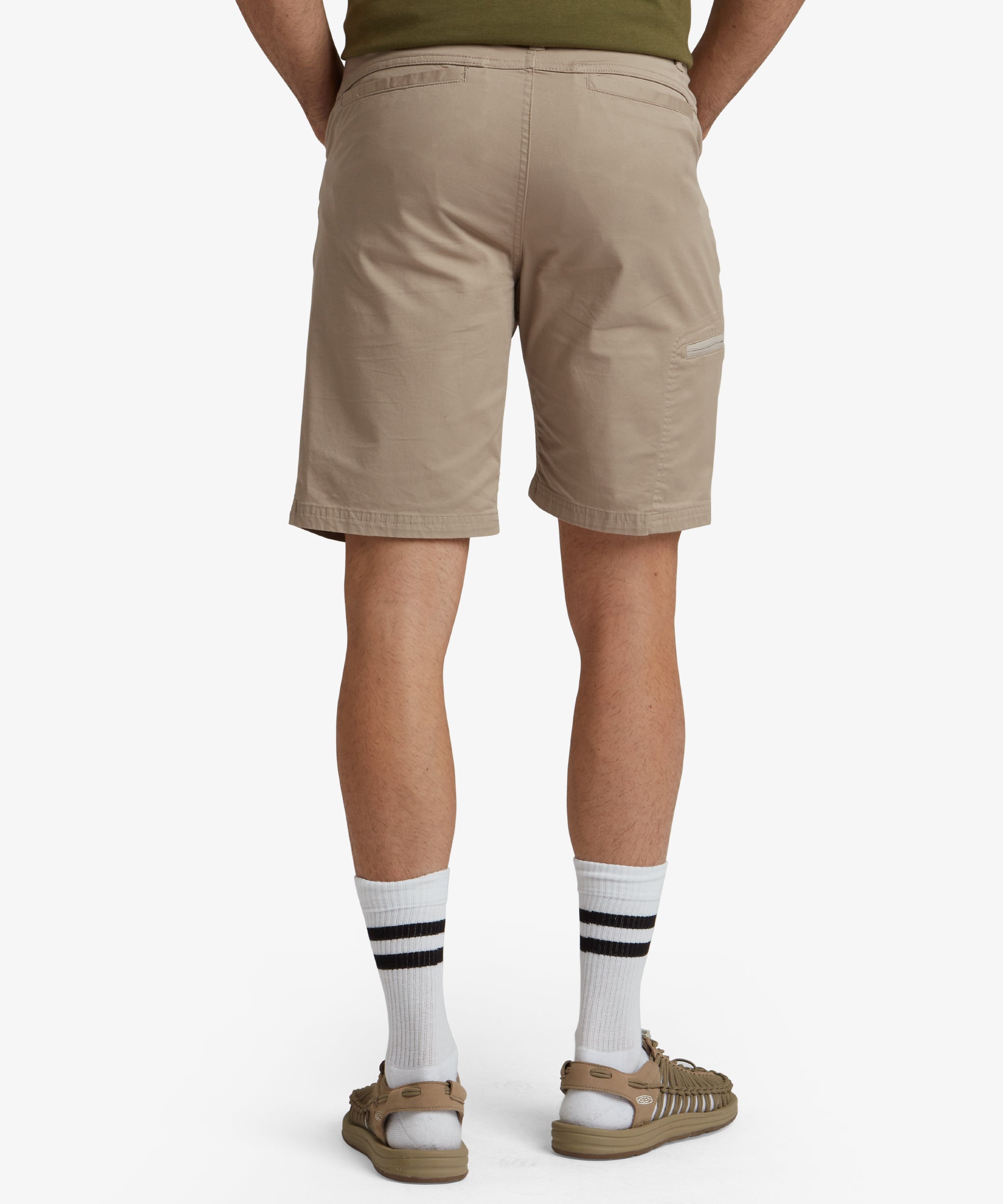 A closer front view of the Sherpa Adventure Gear Tenjing Shorts in Beige worn by the model. The image highlights the texture and design of the shorts, with the model’s hand in the pocket, emphasising the functional aspect.