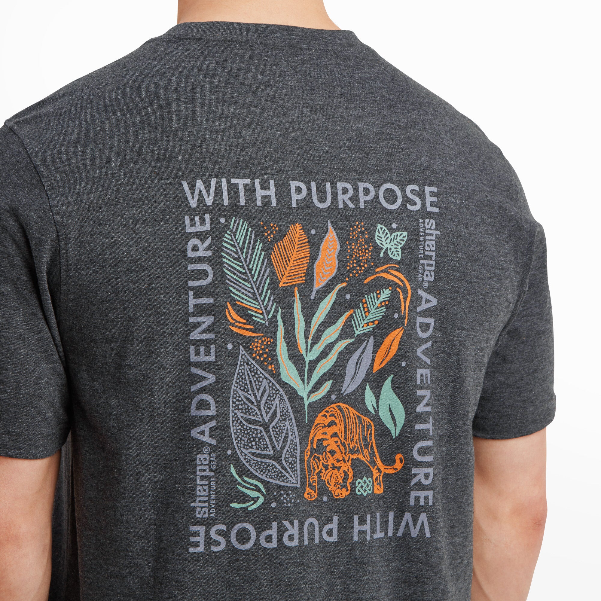 A close-up of the large graphic on the back of the Sherpa Adventure Gear Purpose T-Shirt in Black, showing vibrant details of the tiger, foliage, and text. The artwork features a mix of greens, oranges, and subtle whites, showcasing the intricate design and high-quality print.