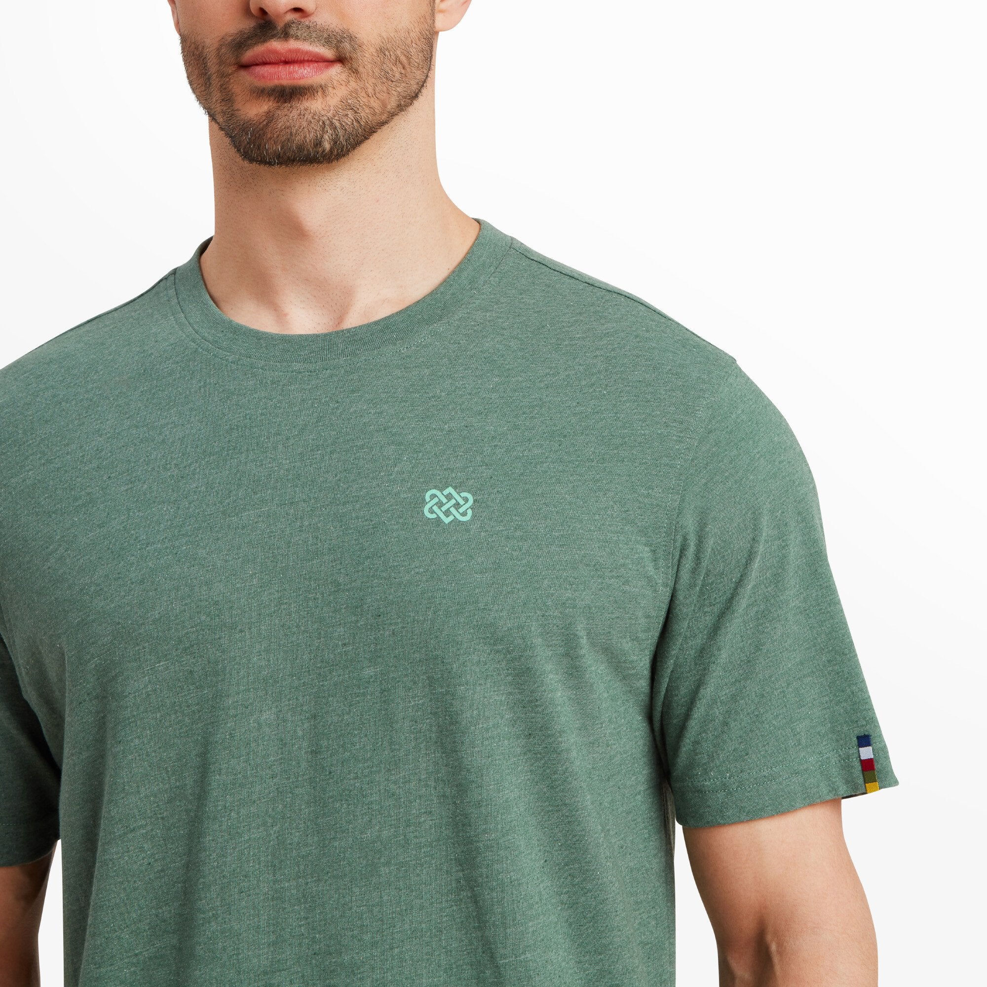 A detailed image of the small Sherpa Adventure logo on the chest of the Sherpa Adventure Gear Terrain T-Shirt in Green. The embroidery is clean and contrasts subtly with the green fabric.