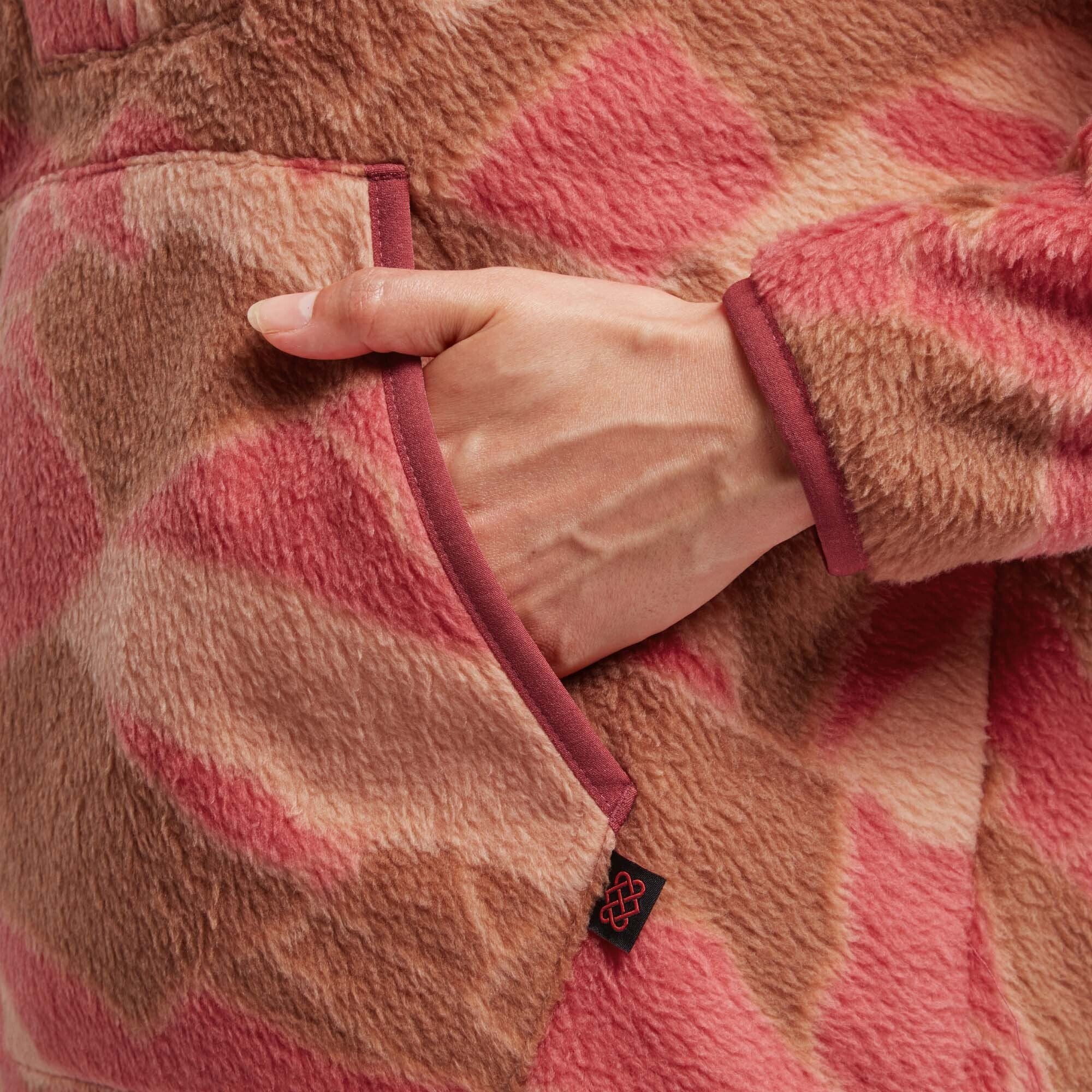 A rear view of the model wearing the Sherpa Adventure Gear Uddesya Eco Quarter Zip in Red. The pullover fits snugly around his shoulders and torso, with clean seam lines running along the back. The slightly curved hem extends just below the waist. The texture of the fabric is visible, and the red color remains vibrant against the plain white background. The model's head is straight, ensuring a clear, unobstructed view of the back design.