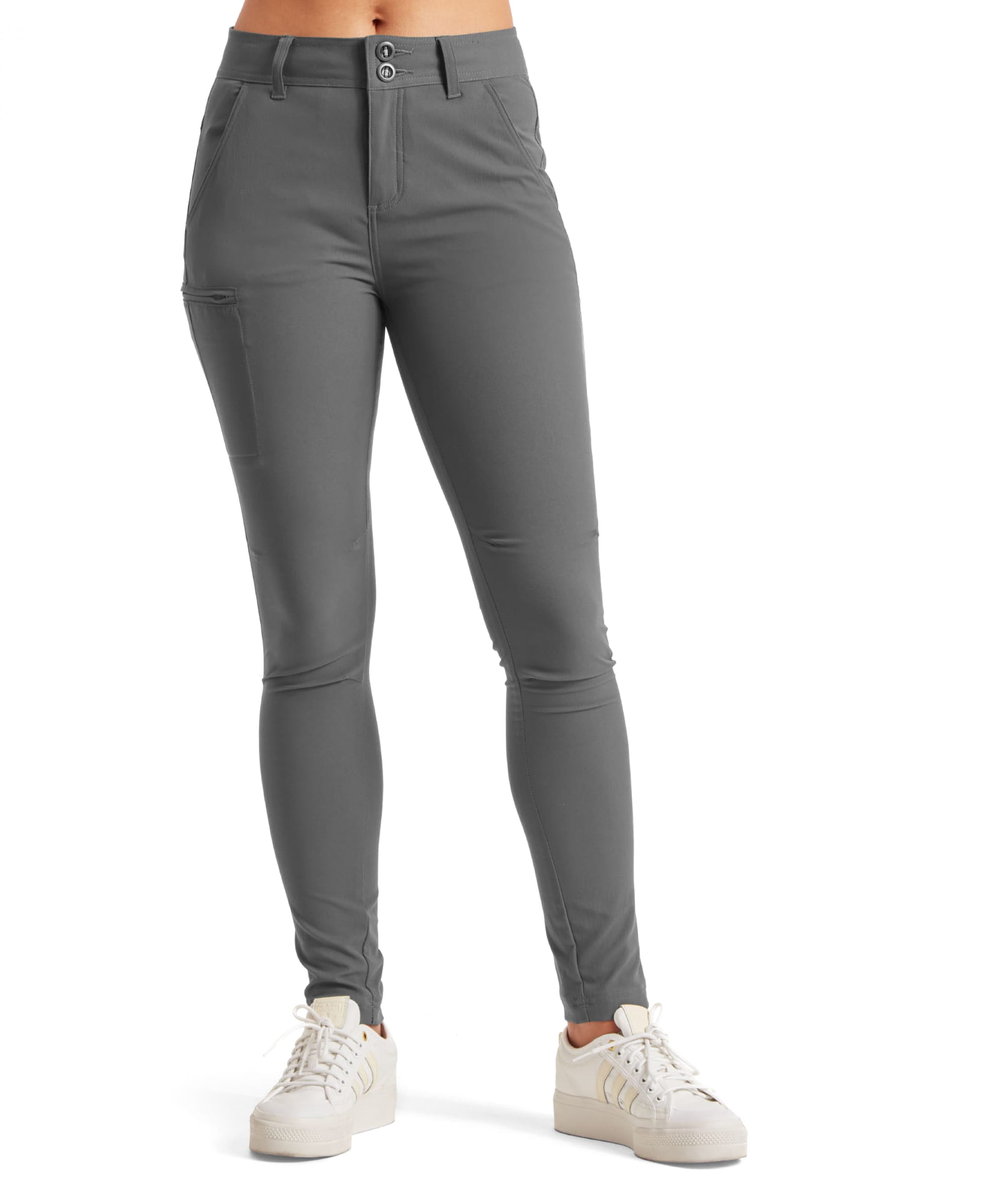 Front view of a pair of Sherpa Adventure Gear Bara Tapered trousers in Grey. The trousers feature a high-rise design with a two-button closure and zip fly, complemented by streamlined seams for a tailored appearance. The model is wearing white trainers, highlighting the trousers' versatility.