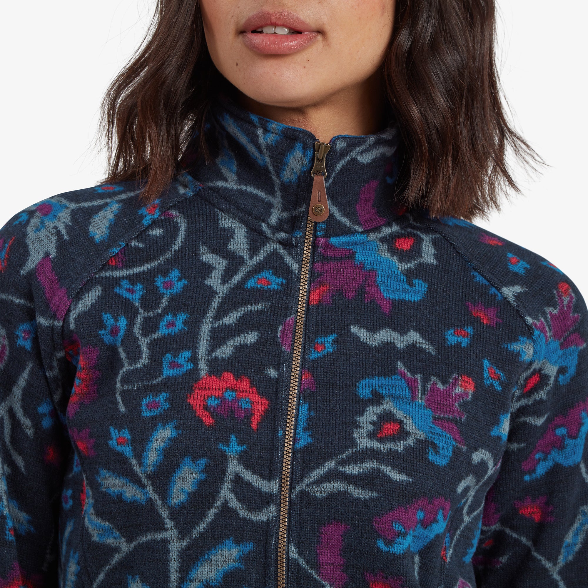 A detailed image focusing on the collar and zipper of the Sherpa Adventure Gear Bhutan Full Zip Jacket in Blue. The brass zipper pull and the intricate pattern on the fabric are highlighted, demonstrating the quality craftsmanship.