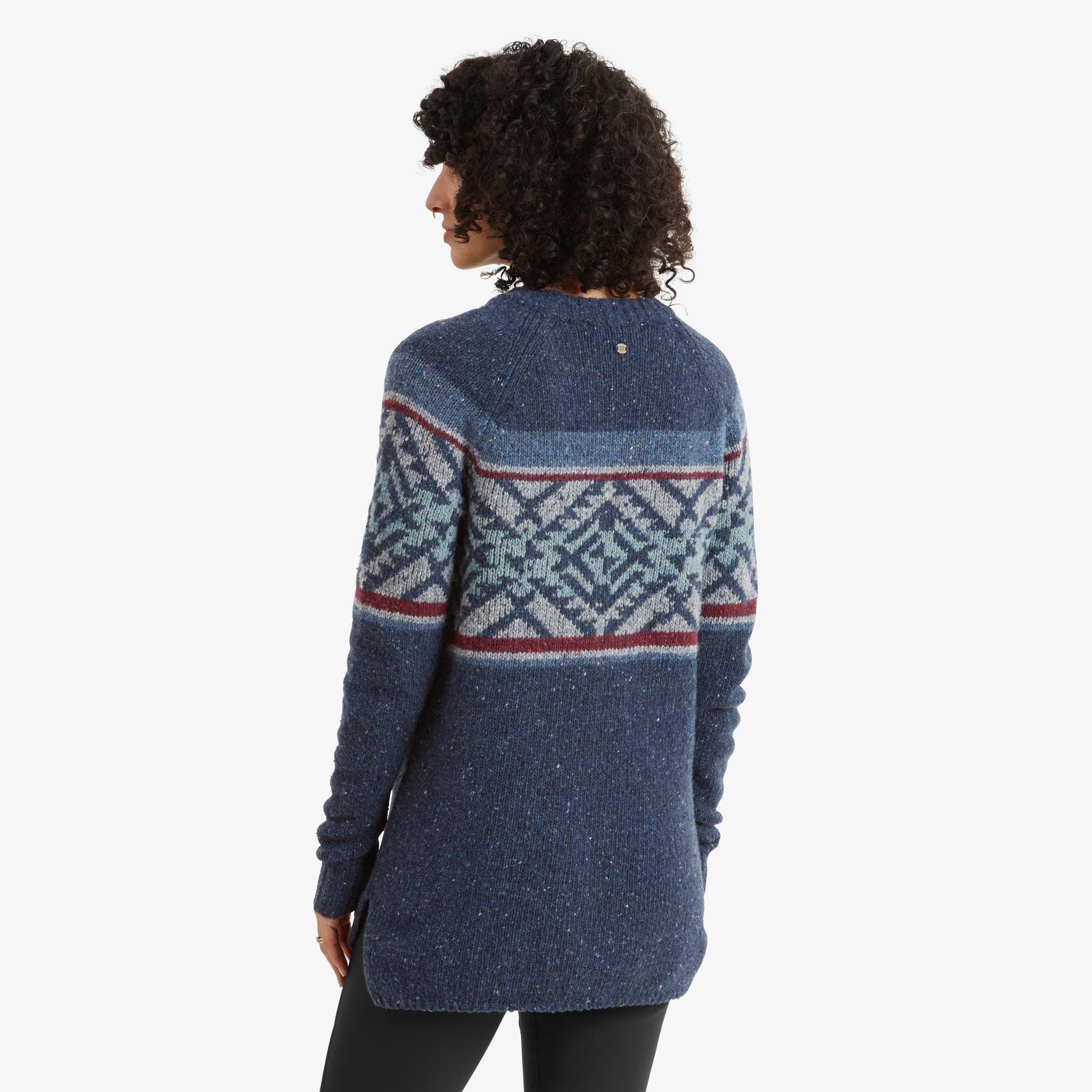 A rear view of the Sherpa Adventure Gear Dumji Long Sweater in Blue, highlighting the back pattern and fit. The geometric design extends across the shoulders and back, with a slightly curved hemline and a visible side slit, providing a flattering shape.