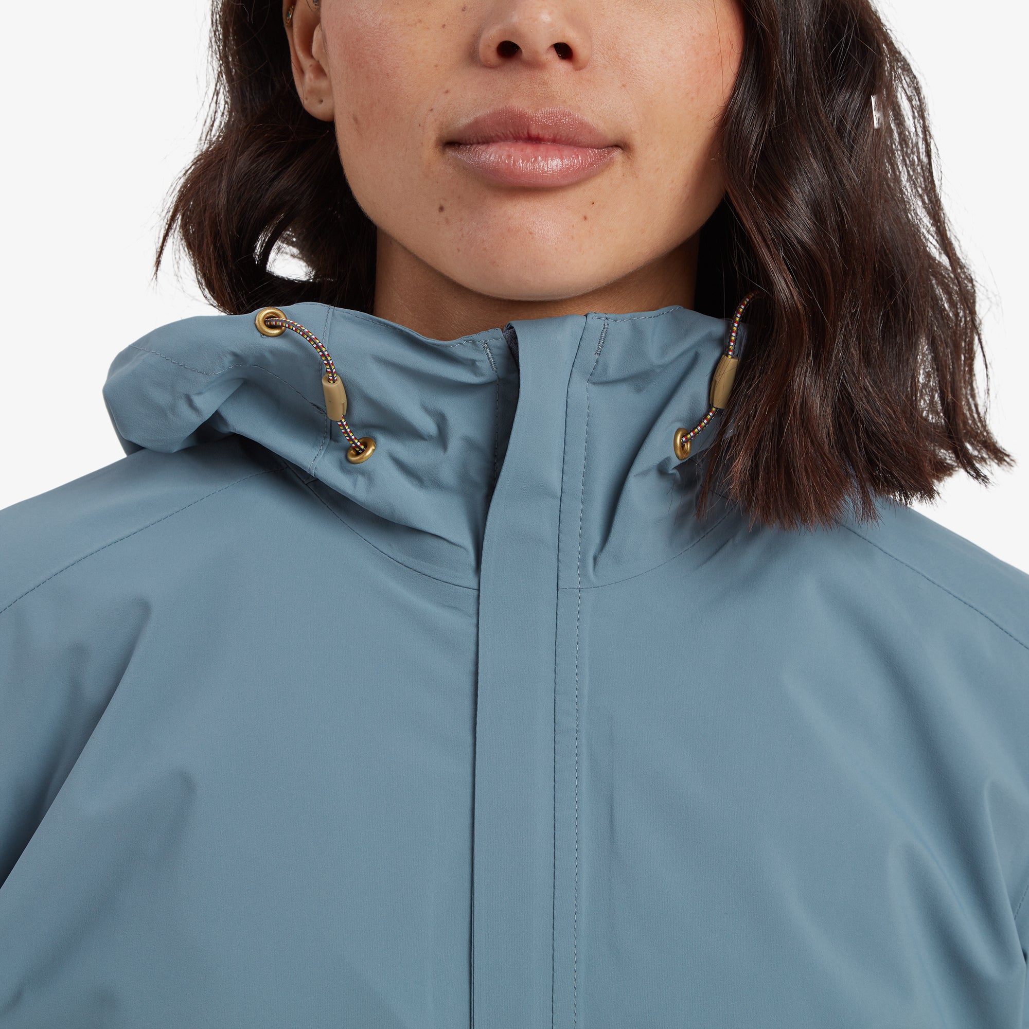 A close-up of the Sherpa Adventure Gear Nima 2.5-Layer Long Jacket in Blue’s high collar with the hood folded down, focusing on the gold drawstring accents and smooth zipper closure for an elegant look.