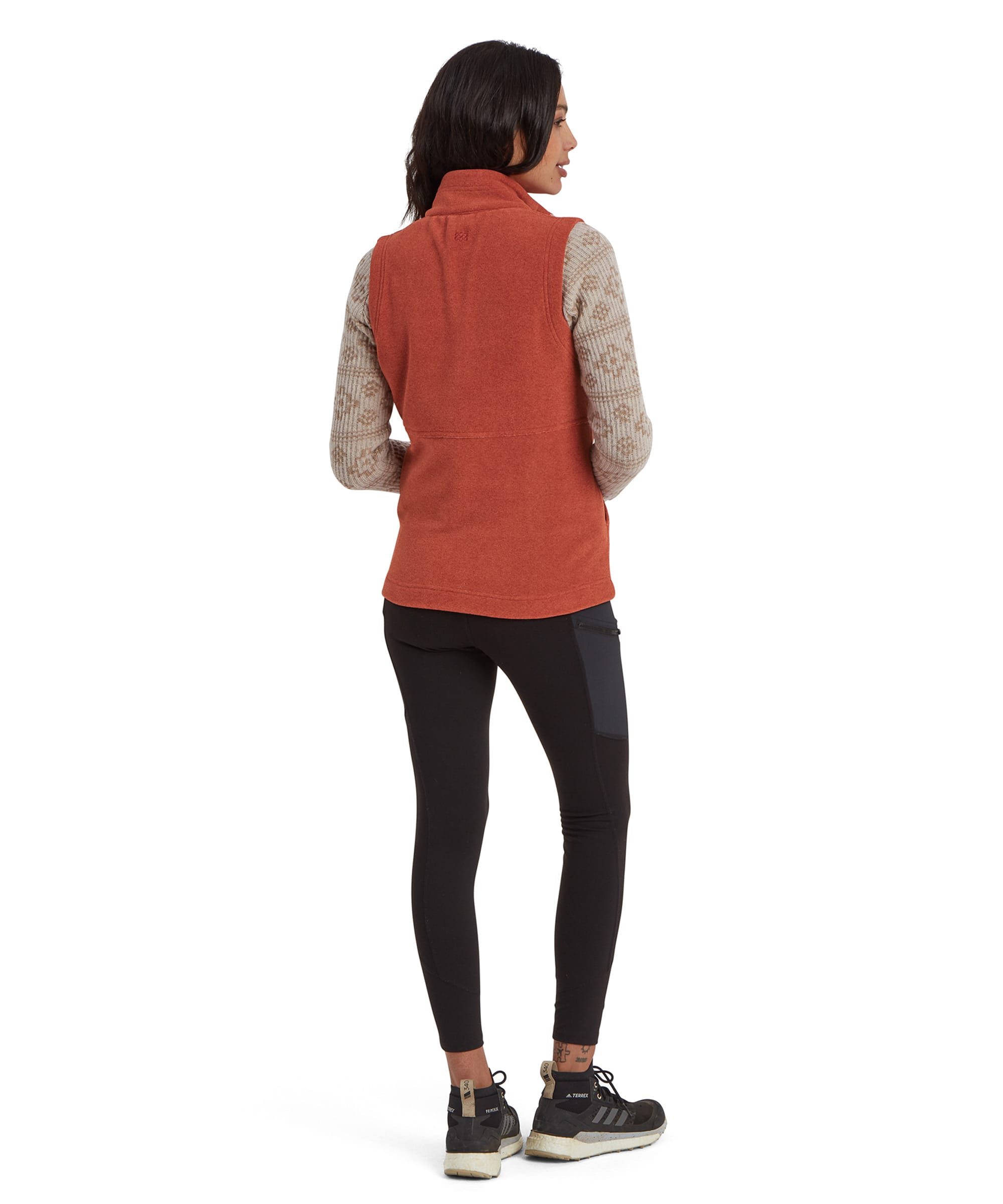 A back view of the outfit showcasing the Sherpa Adventure Gear Rolpa Eco Vest in Brown's simple and functional design. The image emphasises the clean seams and overall construction of the vest while maintaining a relaxed look.