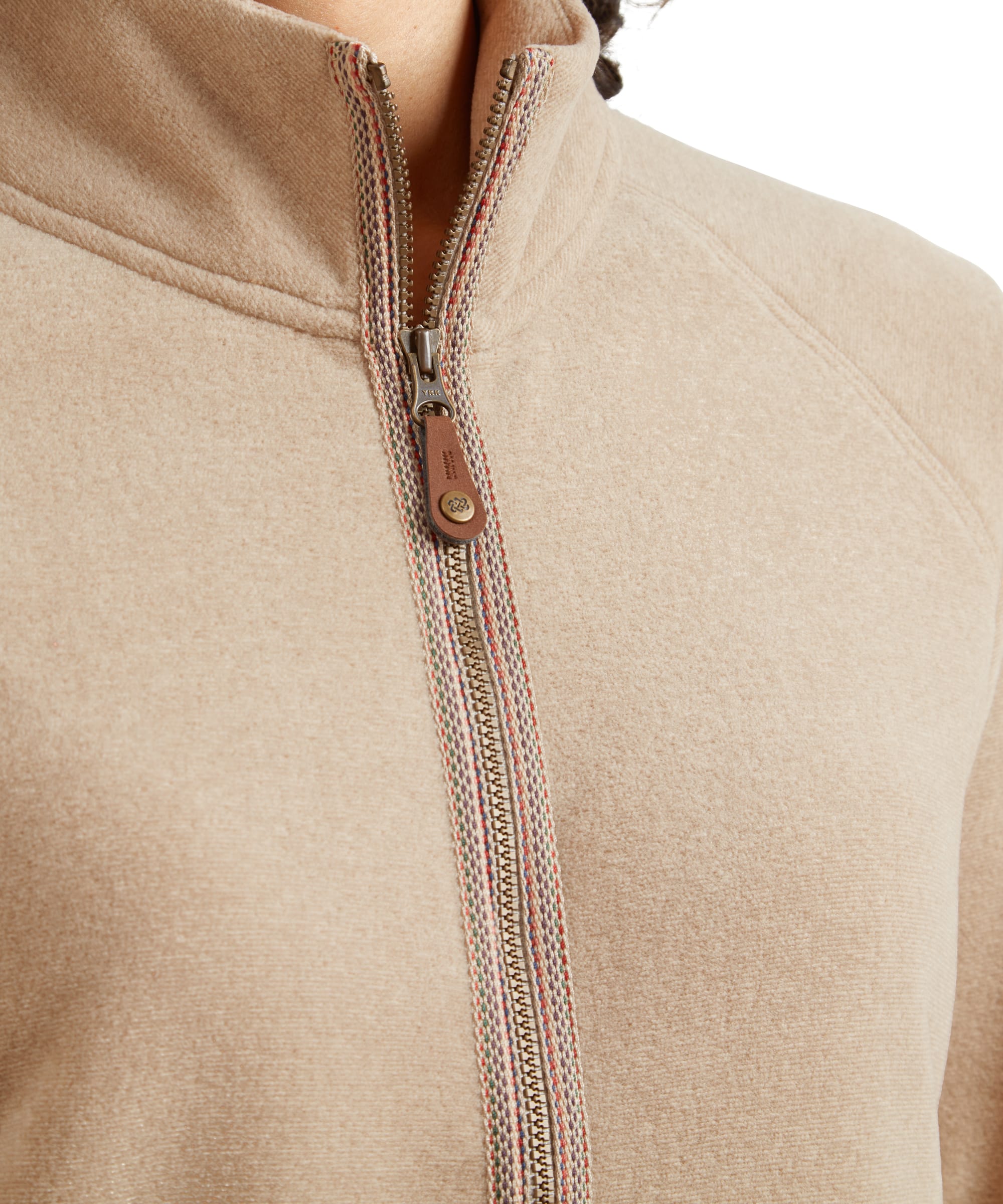 A close-up of the Sherpa Adventure Gear Rolpa Eco Jacket in Beige’s side pocket, with the model’s hand tucked into it. The image highlights the soft fleece texture of the beige fabric and the functional zipper detail, emphasising practicality and warmth. The stitching and neat seams underline the jacket’s quality craftsmanship.