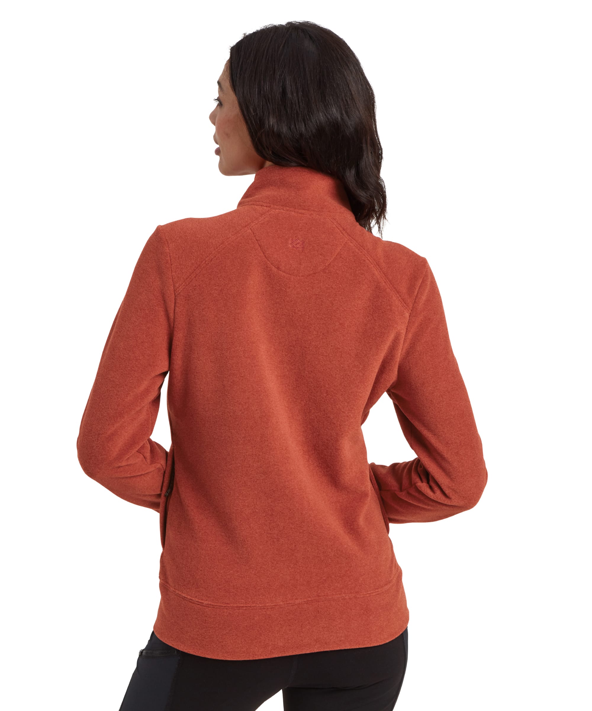 A rear view of the woman in the Sherpa Adventure Gear Rolpa Eco Jacket in Brown, showing the back yoke detail and the gentle curve of the hemline. The collar is standing up slightly, and the sleeves extend comfortably to her wrists. The fabric has a subtle heathered texture.