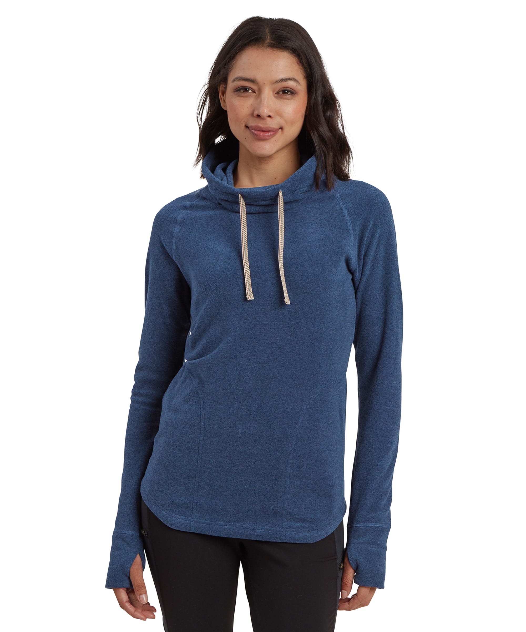 A woman with shoulder-length dark hair is shown wearing a Sherpa Adventure Gear Rolpa Eco Pullover in Blue. The pullover has a high cowl neck with light beige drawstrings hanging down the front. The sweater has long sleeves and thumb holes at the cuffs. She stands with a relaxed posture, looking directly at the camera with a soft smile. The sweater fits snugly and reaches below the hips.