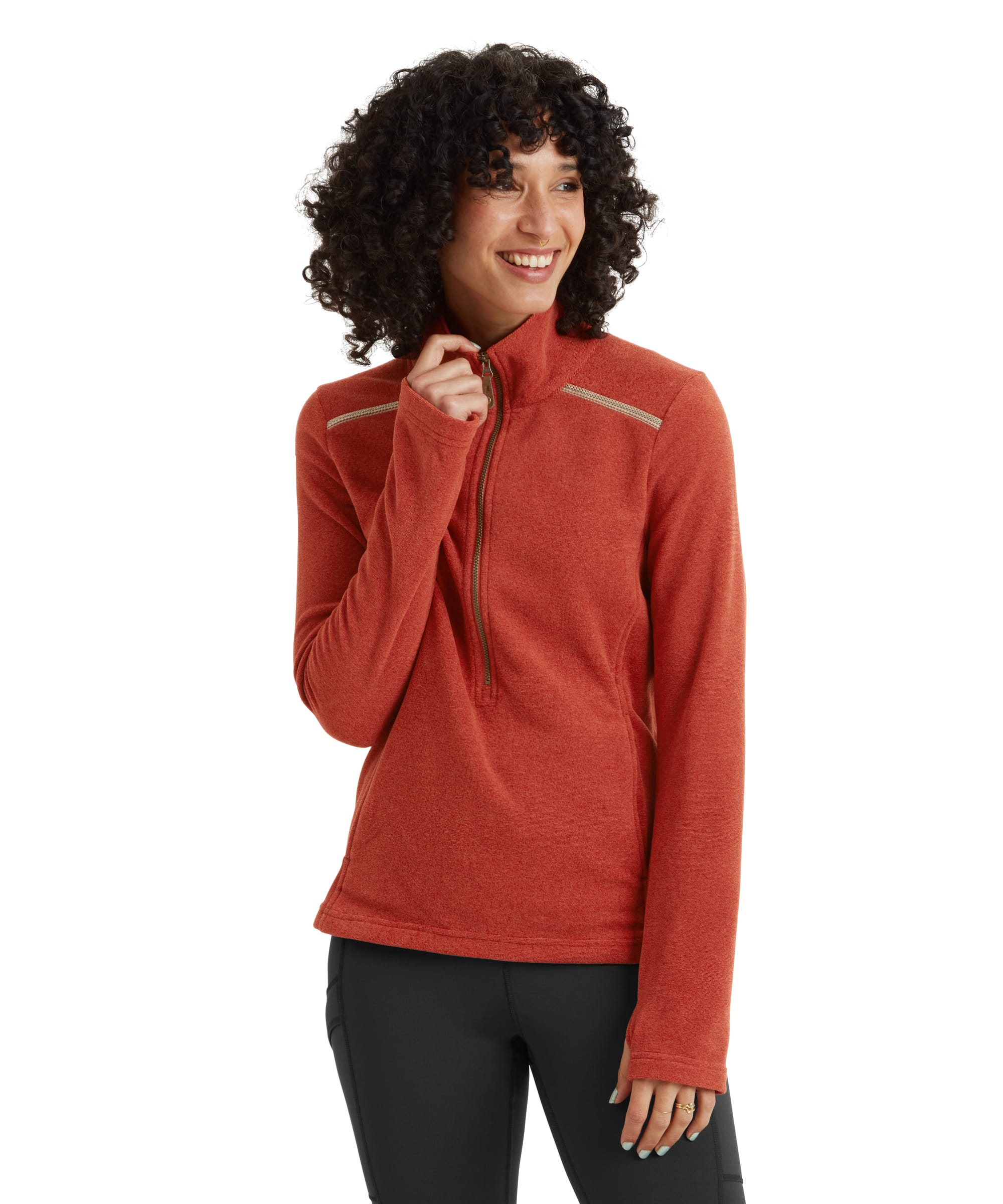 A side profile view of a model wearing an Sherpa Adventure Gear Rolpa Eco Pullover Zip in Brown. The garment features a zippered neckline, contrast stitching on the shoulders, and a soft, brushed texture. The model has curly hair and is paired with black leggings for a casual, outdoorsy look.