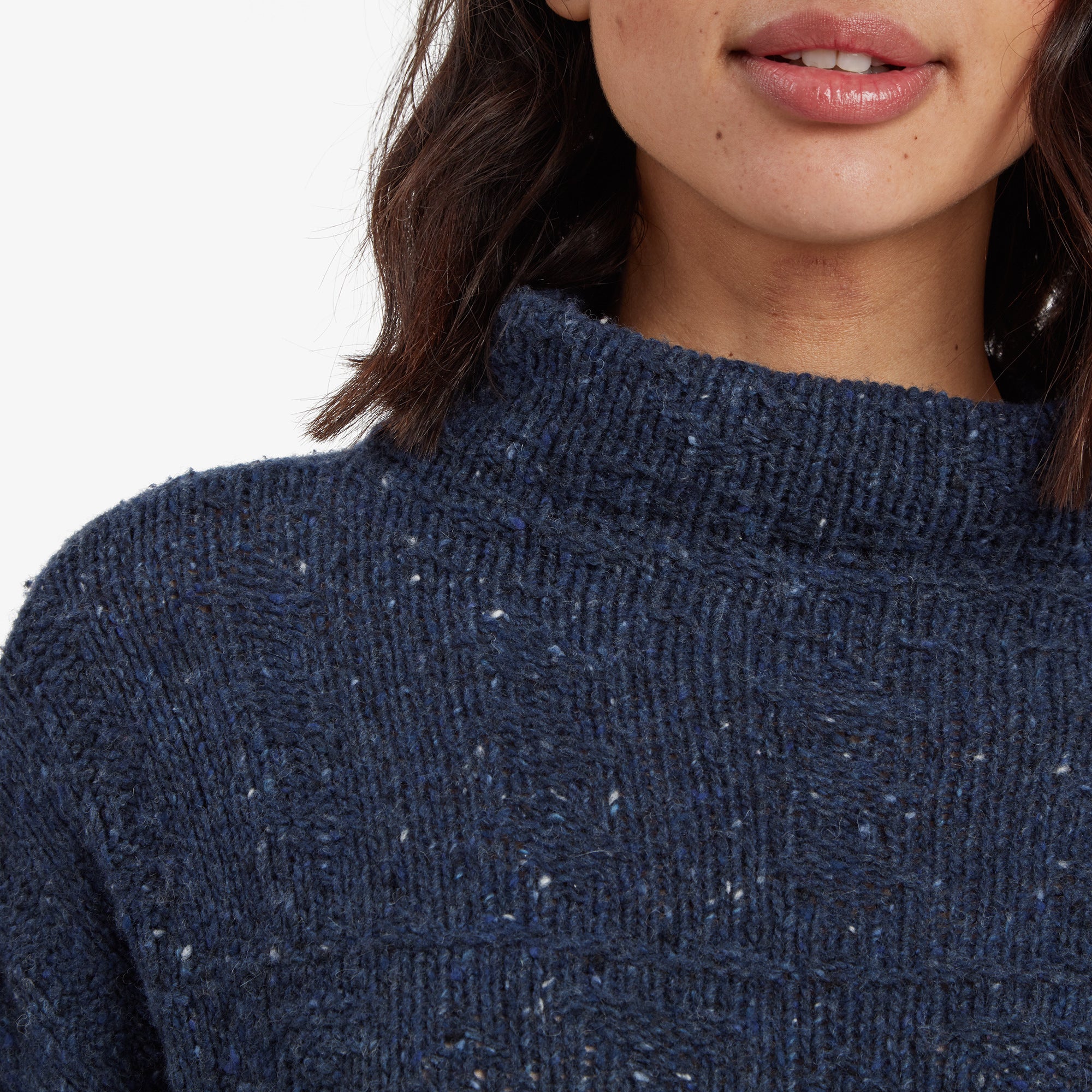 A close-up of the Sherpa Adventure Gear Yuden Pullover Sweater in Blue's neckline, featuring the high collar and intricate ribbed knit detailing. The textured material and subtle flecks of white in the blue fabric are prominently displayed.