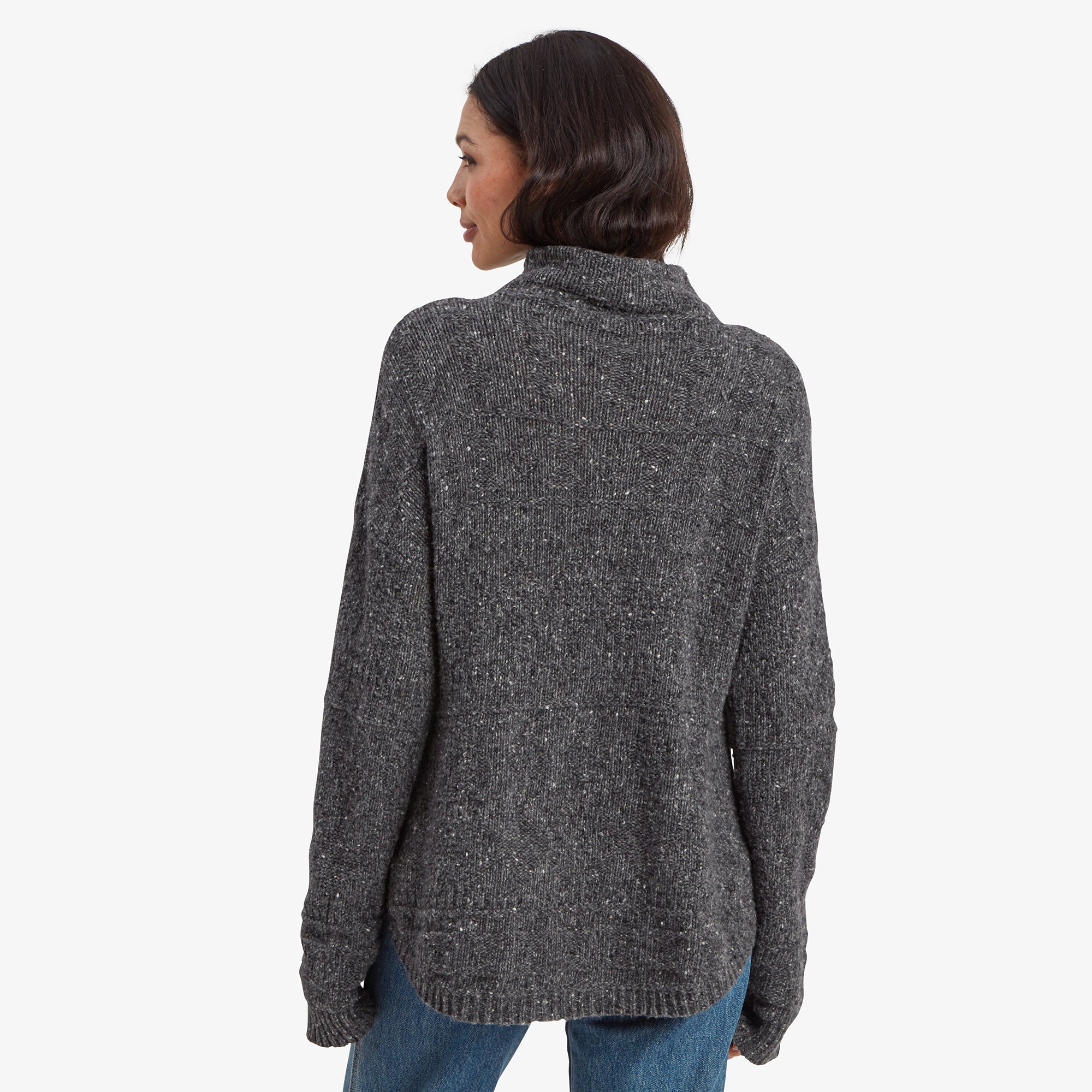 A back view of the Sherpa Adventure Gear Yuden Pullover Sweater in Grey, showcasing its longer curved hemline and seamless knit design. The high neckline wraps around the back of the neck, adding to the sweater's cozy appeal.