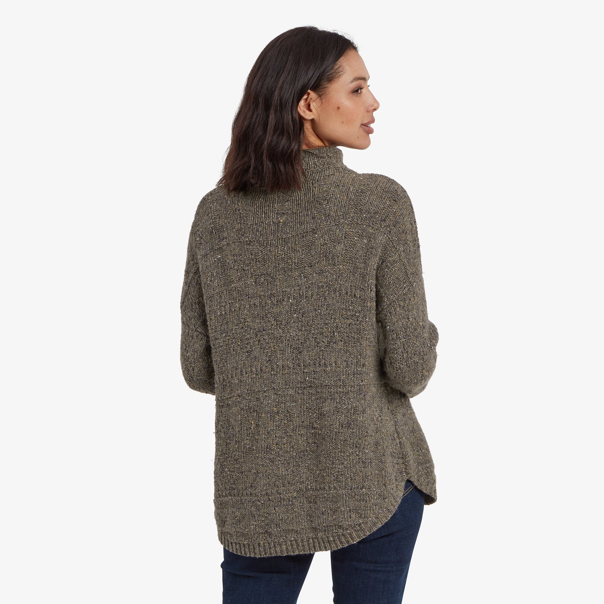 A back view of the Sherpa Adventure Gear Yuden Pullover Sweater in Grey, showing the curved hem and textured knitting pattern. The sweater drapes casually, paired with dark blue jeans, emphasising its relaxed and comfortable design.