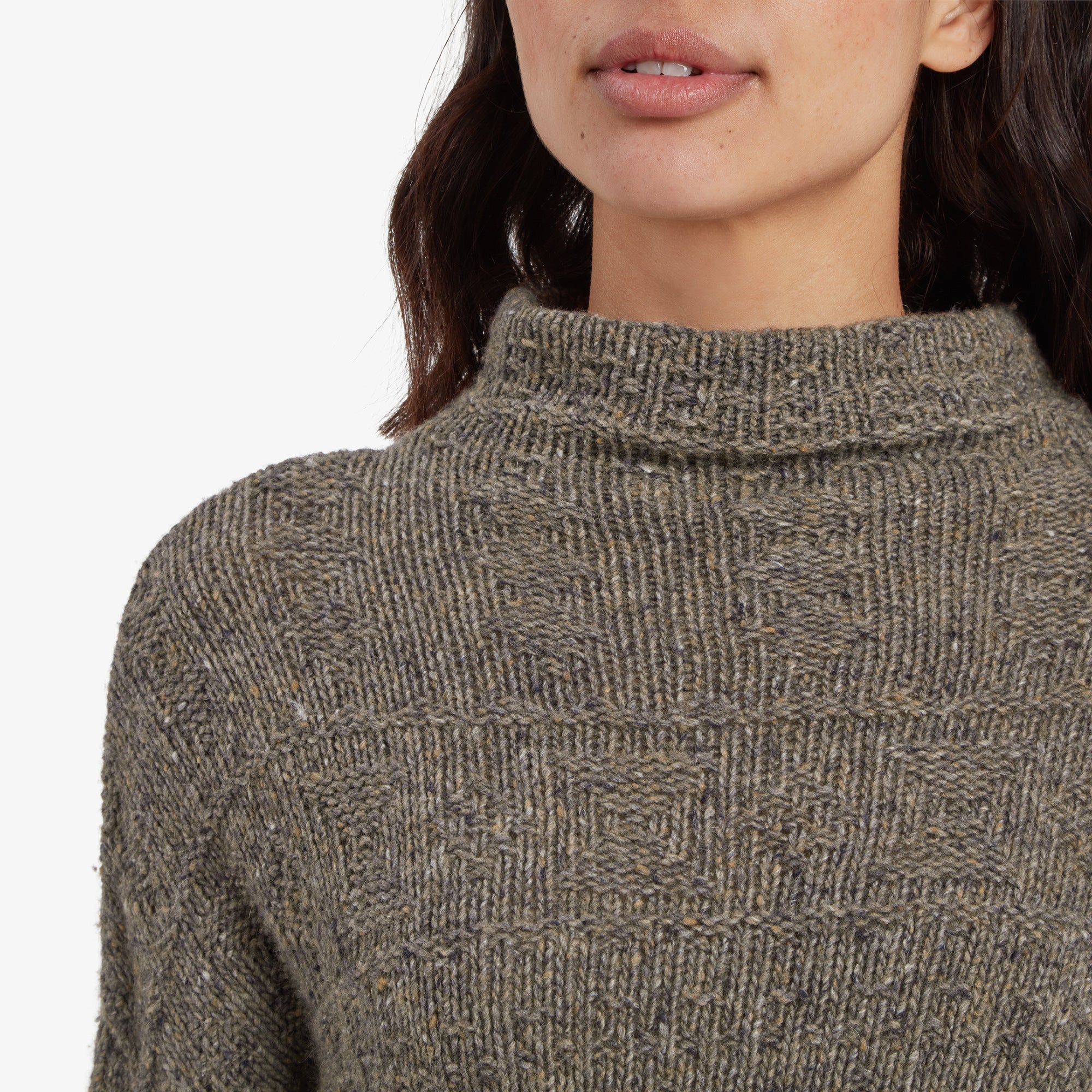 A close-up of the Sherpa Adventure Gear Yuden Pullover Sweater in Grey’s neckline and upper torso. The high neckline features a ribbed texture, and the detailed knit pattern of the sweater is prominently displayed. The image highlights the intricate craftsmanship of the fabric.